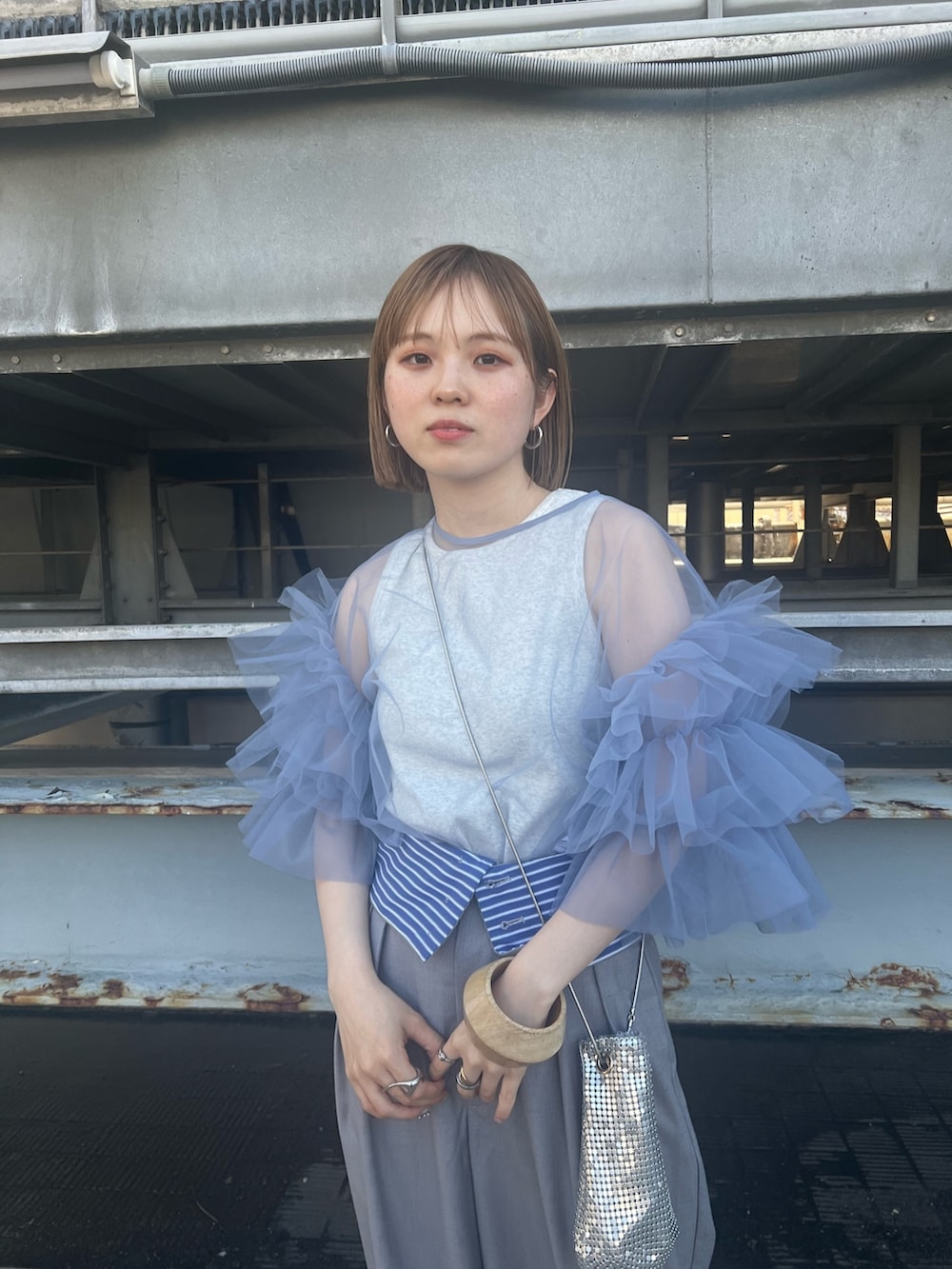 グレー系のその他パンツ、グリーン系のショルダーバッグ、ベージュ系のタンクトップを着用したレディースの春コーディネートの3枚目の写真