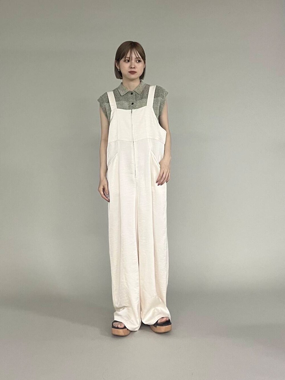 ブラウン系のサンダル、ベージュ系のニット/セーター、ホワイト系のサロペット/オーバーオールを着用したレディースの夏コーディネートの2枚目の写真