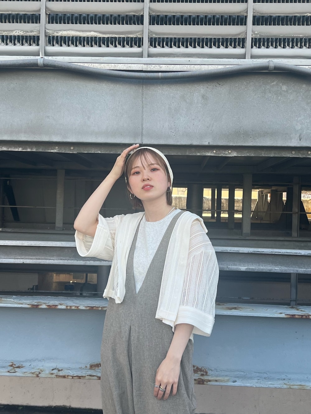 イエロー系のサンダル、ベージュ系のサロペット/オーバーオール、ベージュ系のタンクトップを着用したレディースの春コーディネートの3枚目の写真