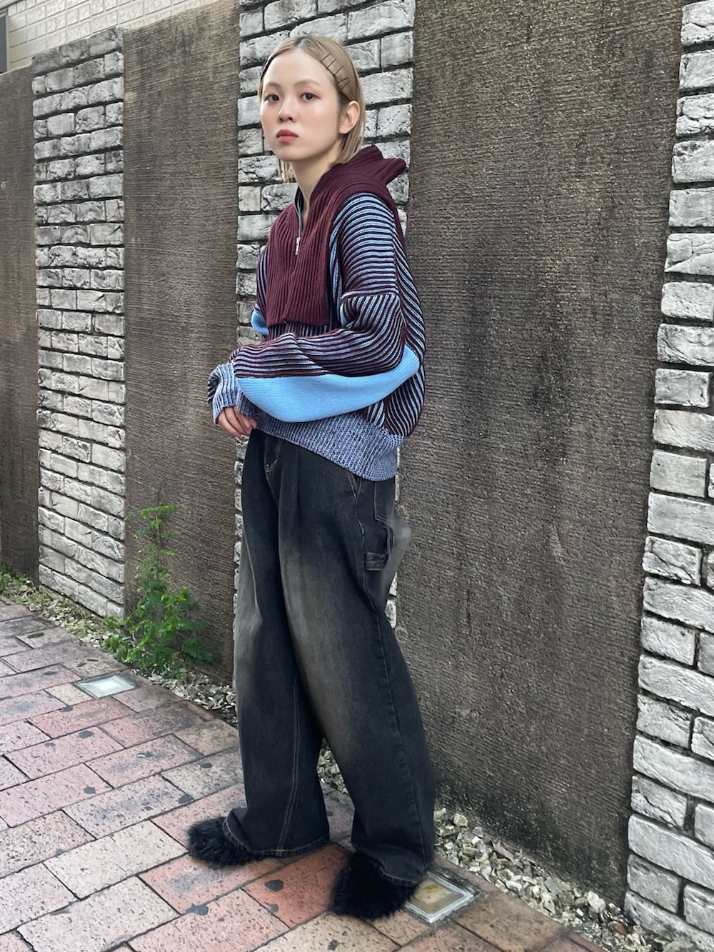 ブラック系のデニムパンツ、ブラック系のパンプス、ブルー系のニット/セーターを着用したレディースの秋コーディネートの2枚目の写真