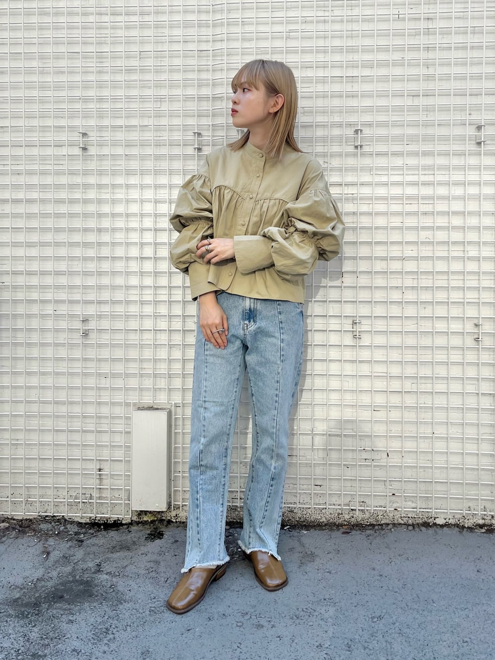 ブルー系のデニムパンツ、ブラウン系のその他シューズ、ベージュ系のシャツ/ブラウスを着用したレディースの秋コーディネートの3枚目の写真