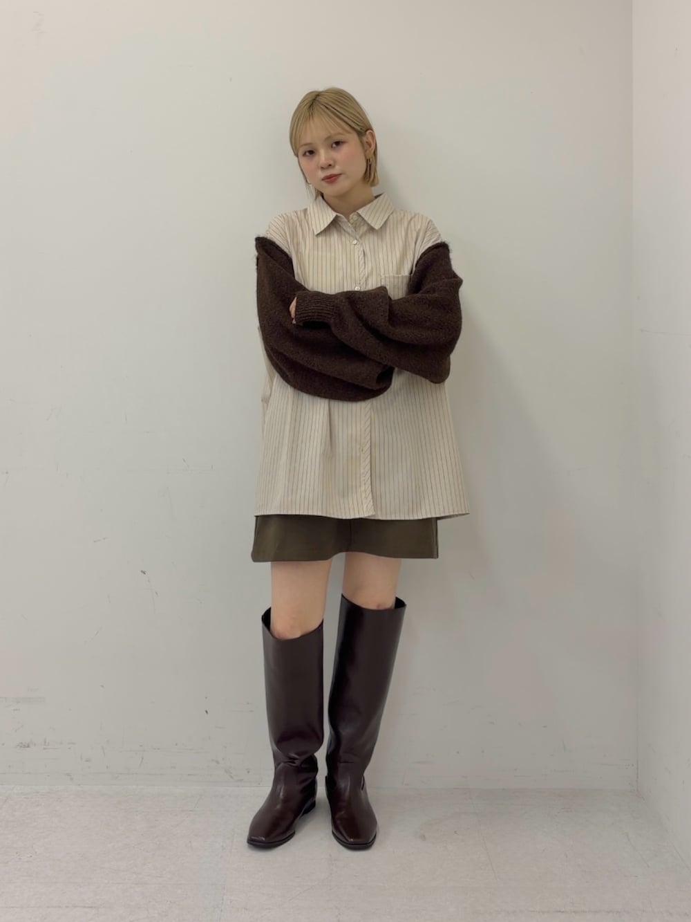 ベージュ系のシャツ/ブラウス、グレー系のスカート、ブラウン系のブーツを着用したレディースの秋コーディネートの2枚目の写真