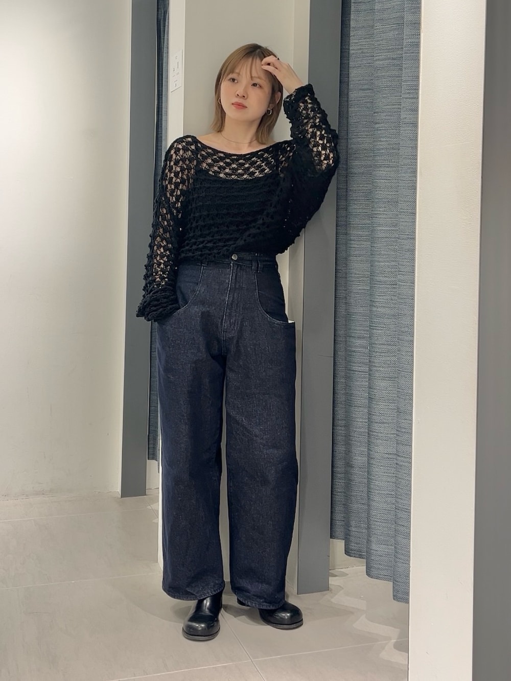 ブルー系のデニムパンツ、ブラック系のサンダル、ブラック系のニット/セーターを着用したレディースの春コーディネートの3枚目の写真