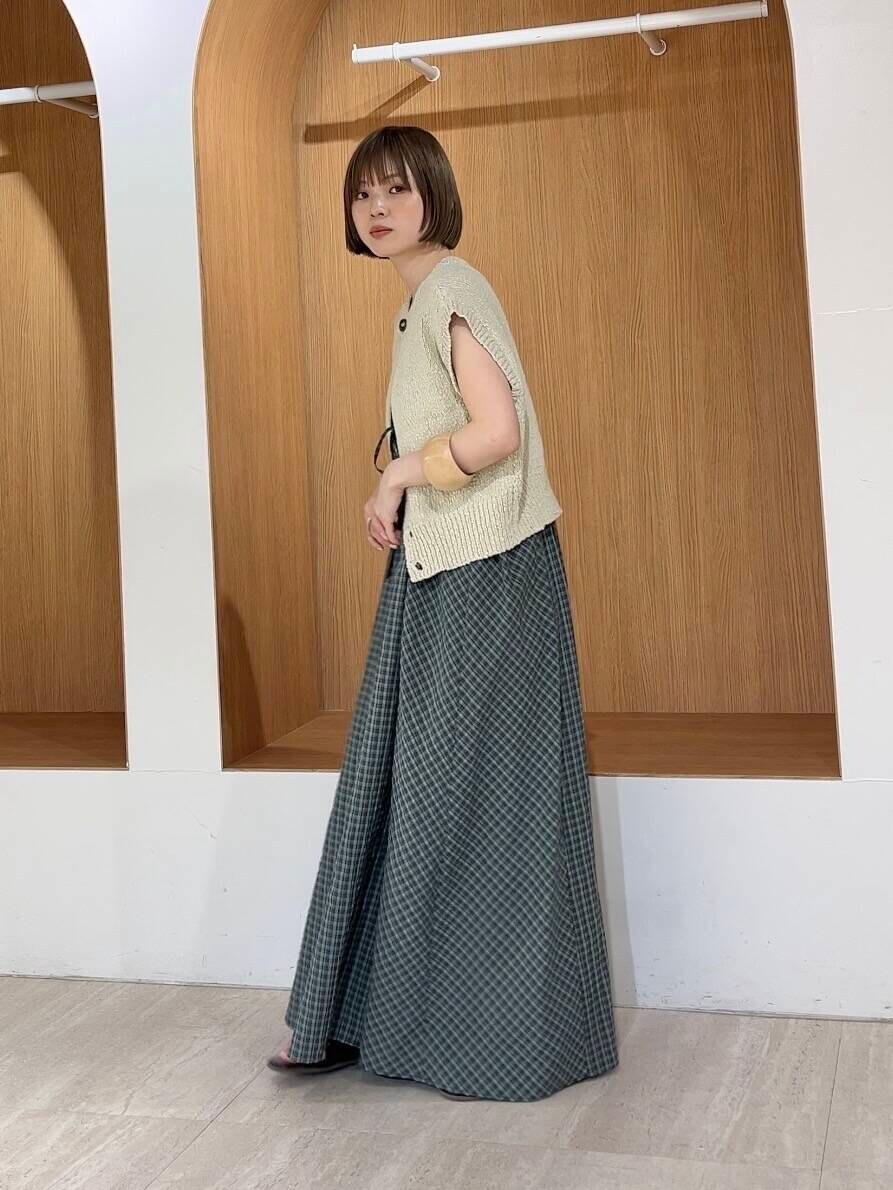 ベージュ系のニット/セーター、グリーン系のワンピース、レッド系のサンダルを着用したレディースの春コーディネートの3枚目の写真