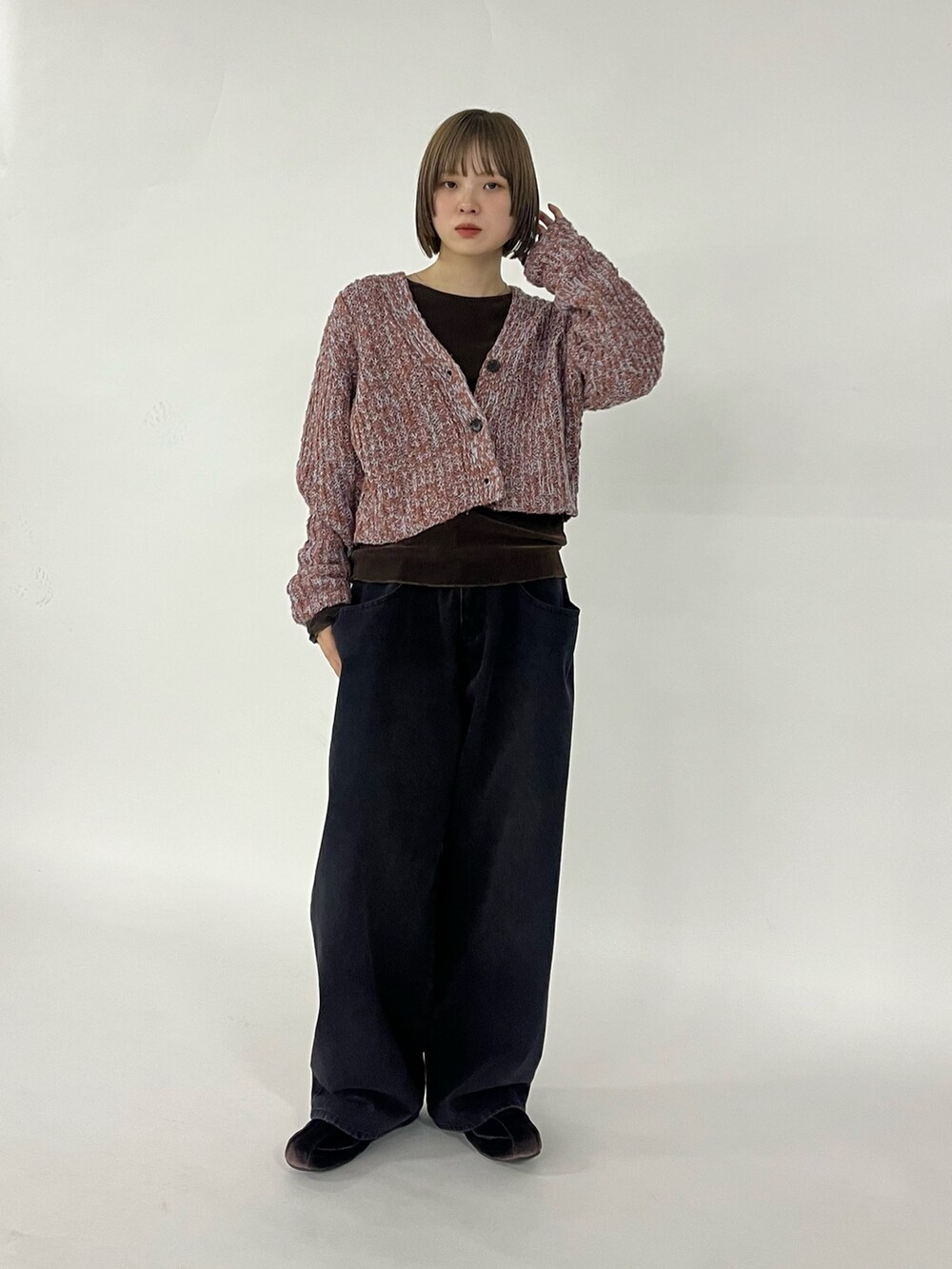 ブラック系のデニムパンツ、ブラウン系のスニーカー、ブラウン系のニット/セーターを着用したレディースの秋コーディネートの5枚目の写真