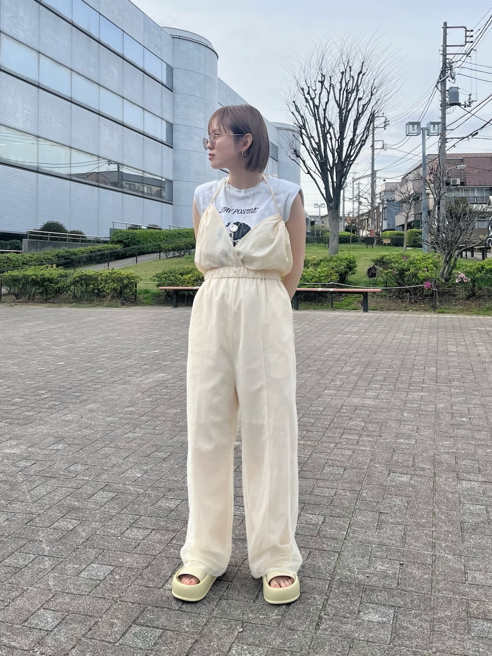 イエロー系のサンダル、ホワイト系のサロペット/オーバーオールを着用したレディースの春コーディネートの2枚目の写真