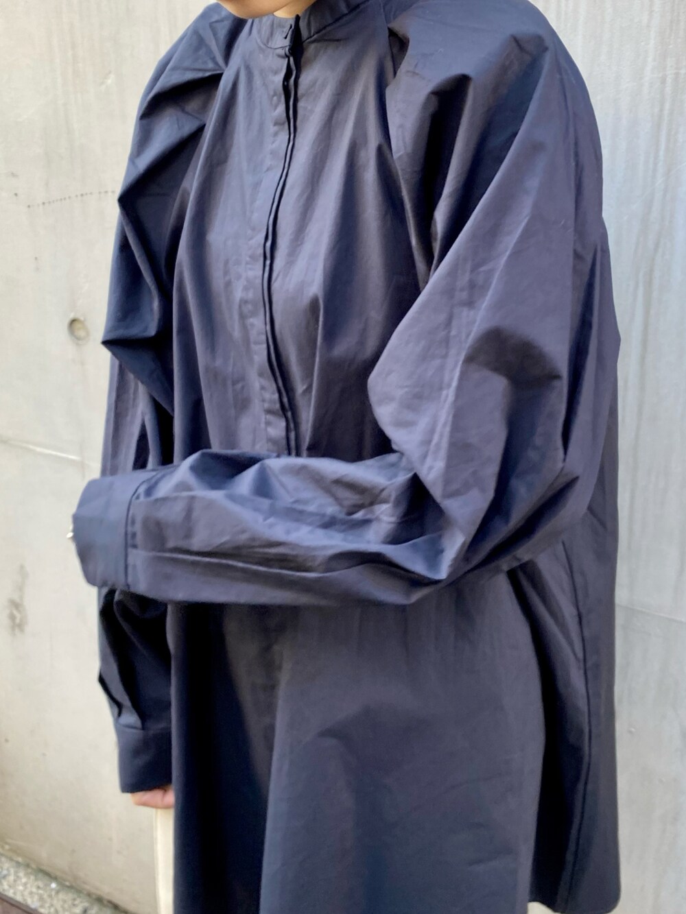 ブラック系のショルダーバッグ、ベージュ系のスカート、ブルー系のシャツ/ブラウスを着用したレディースの冬コーディネートの3枚目の写真