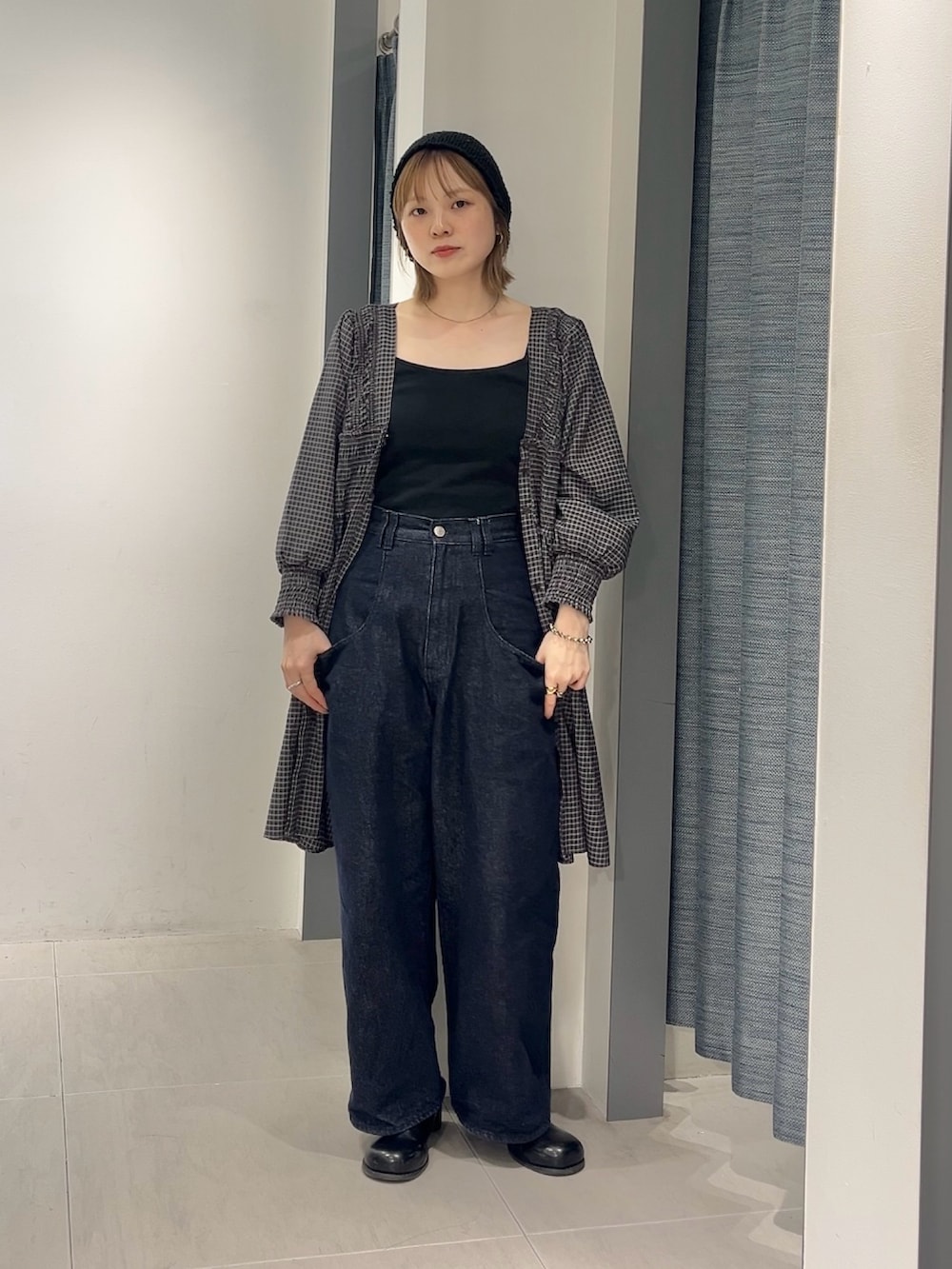 ブルー系のデニムパンツ、ブラウン系のワンピース、ブラック系のサンダルを着用したレディースの春コーディネートの3枚目の写真