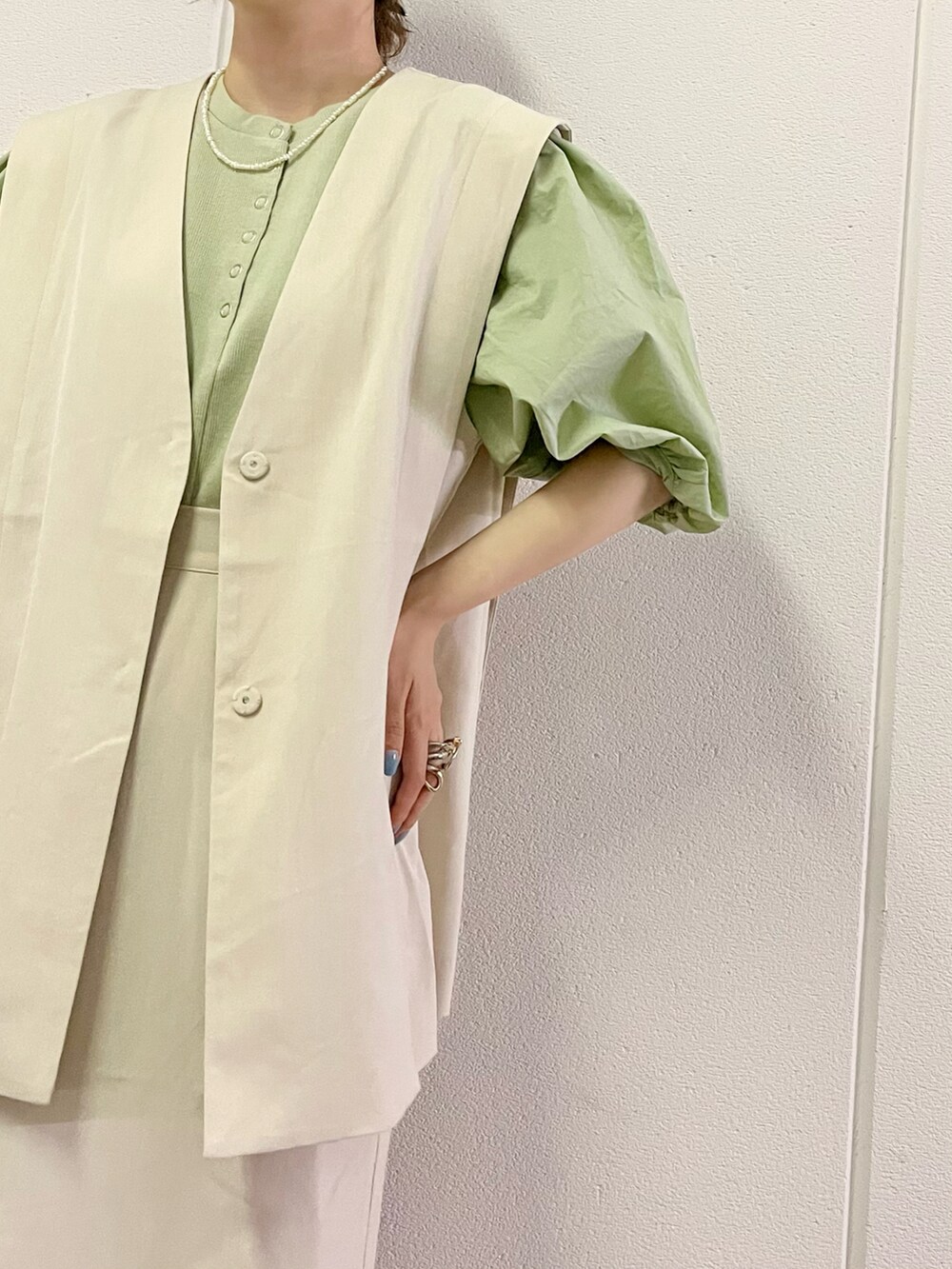 グリーン系のショルダーバッグ、ホワイト系のサンダル、ベージュ系のワンピースを着用したレディースの夏コーディネートの3枚目の写真