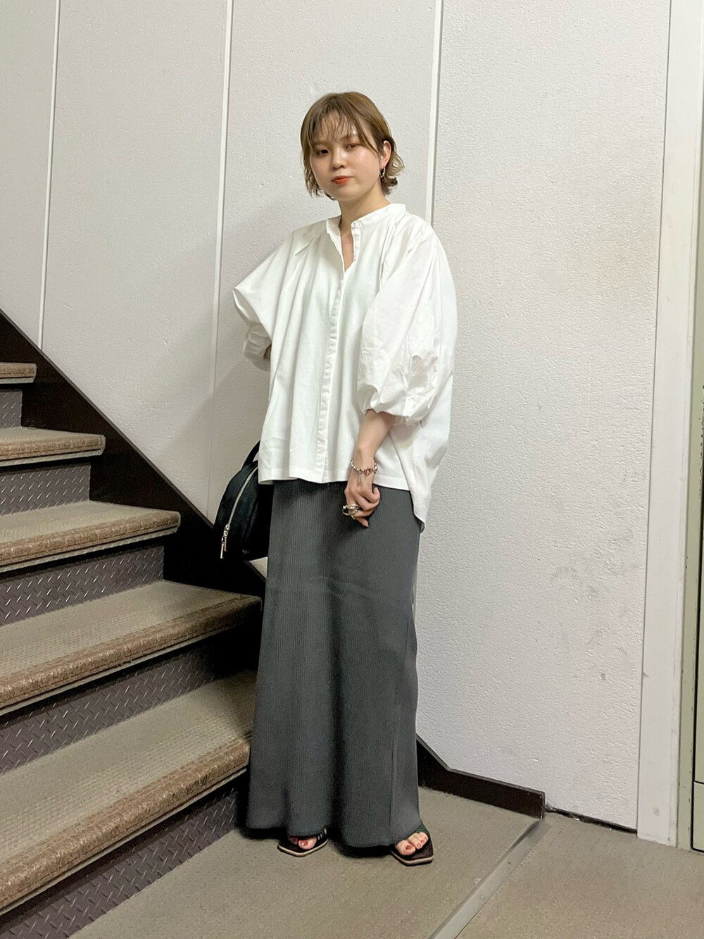 ホワイト系のシャツ/ブラウス、グレー系のスカート、ブラック系のボストンバッグを着用したレディースの夏コーディネートの4枚目の写真