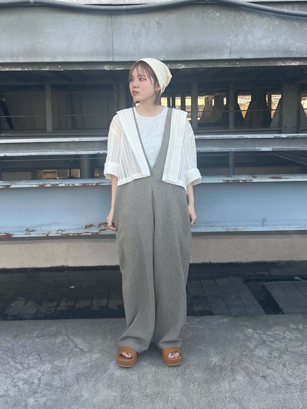 イエロー系のサンダル、ベージュ系のサロペット/オーバーオール、ベージュ系のタンクトップを着用したレディースの春コーディネートの2枚目の写真