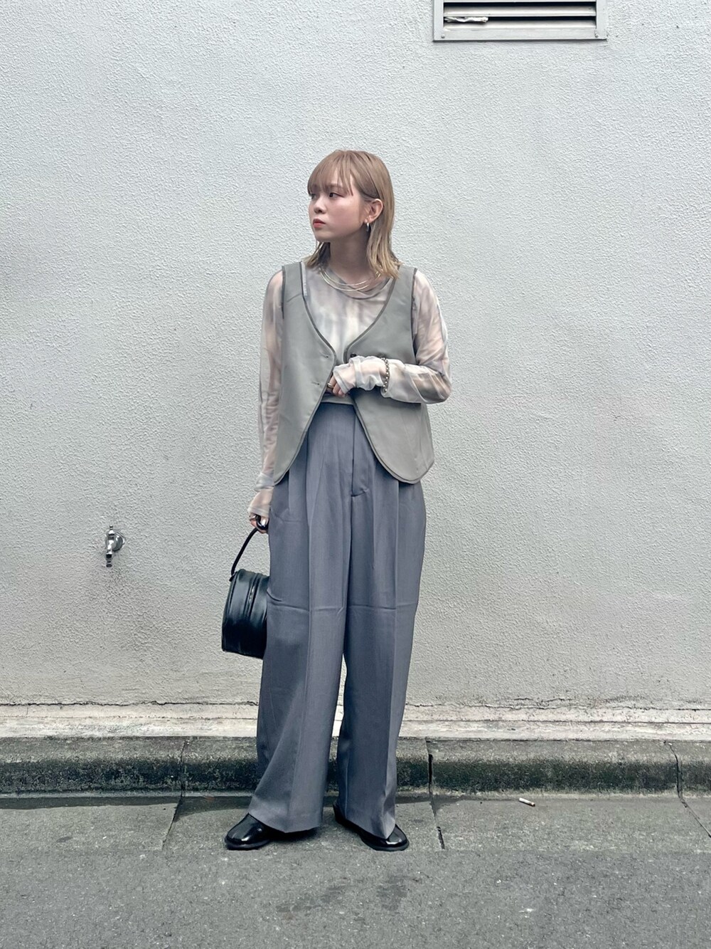 ブラック系のその他シューズ、ブラック系のハンドバッグ、グレー系のその他パンツを着用したレディースの夏コーディネートの4枚目の写真