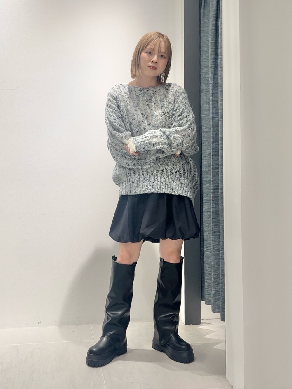 ブルー系のニット/セーター、ホワイト系のTシャツ/カットソー、グレー系のスカートを着用したレディースの秋コーディネートの4枚目の写真