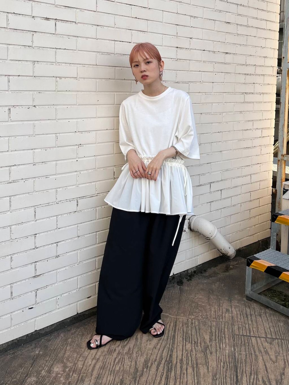 ブラック系のセットアップ、ブラック系のサンダル、ホワイト系のTシャツ/カットソーを着用したレディースの夏コーディネートの4枚目の写真