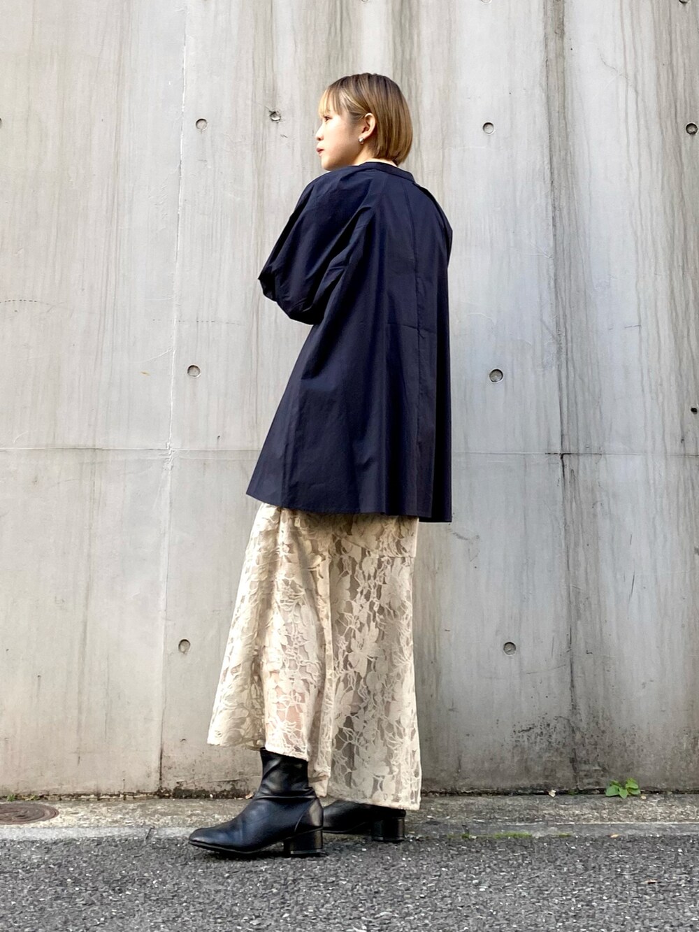 ブラック系のショルダーバッグ、ベージュ系のスカート、ブルー系のシャツ/ブラウスを着用したレディースの冬コーディネートの5枚目の写真