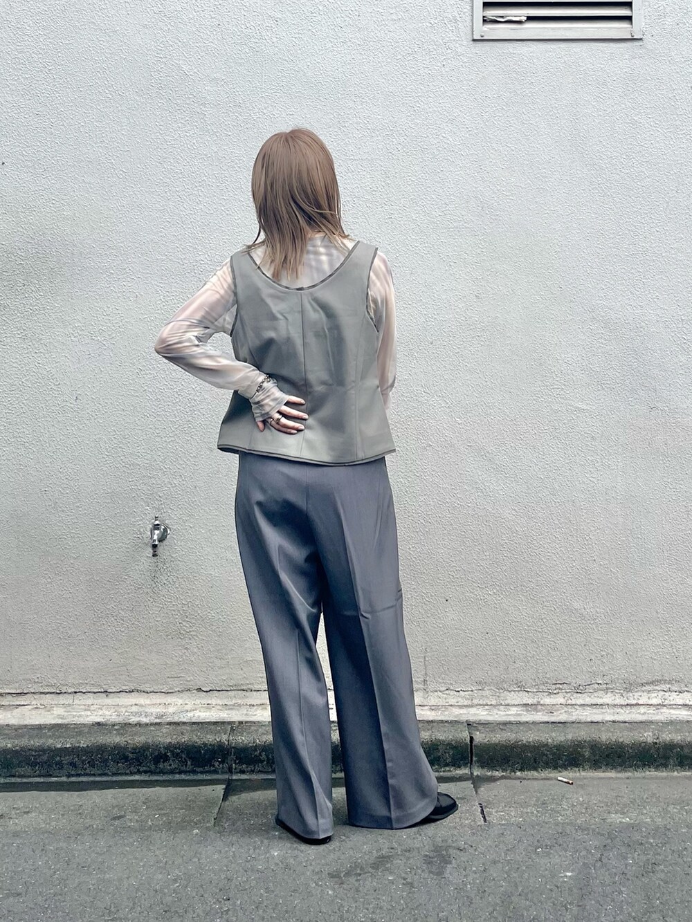 ブラック系のその他シューズ、ブラック系のハンドバッグ、グレー系のその他パンツを着用したレディースの夏コーディネートの3枚目の写真