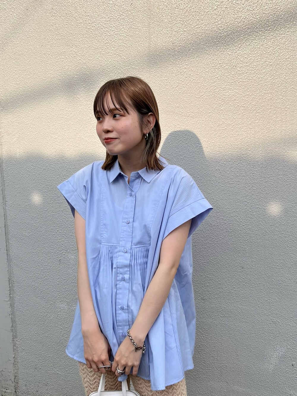 ホワイト系のサンダル、ホワイト系のハンドバッグ、ベージュ系のその他パンツを着用したレディースの夏コーディネートの2枚目の写真