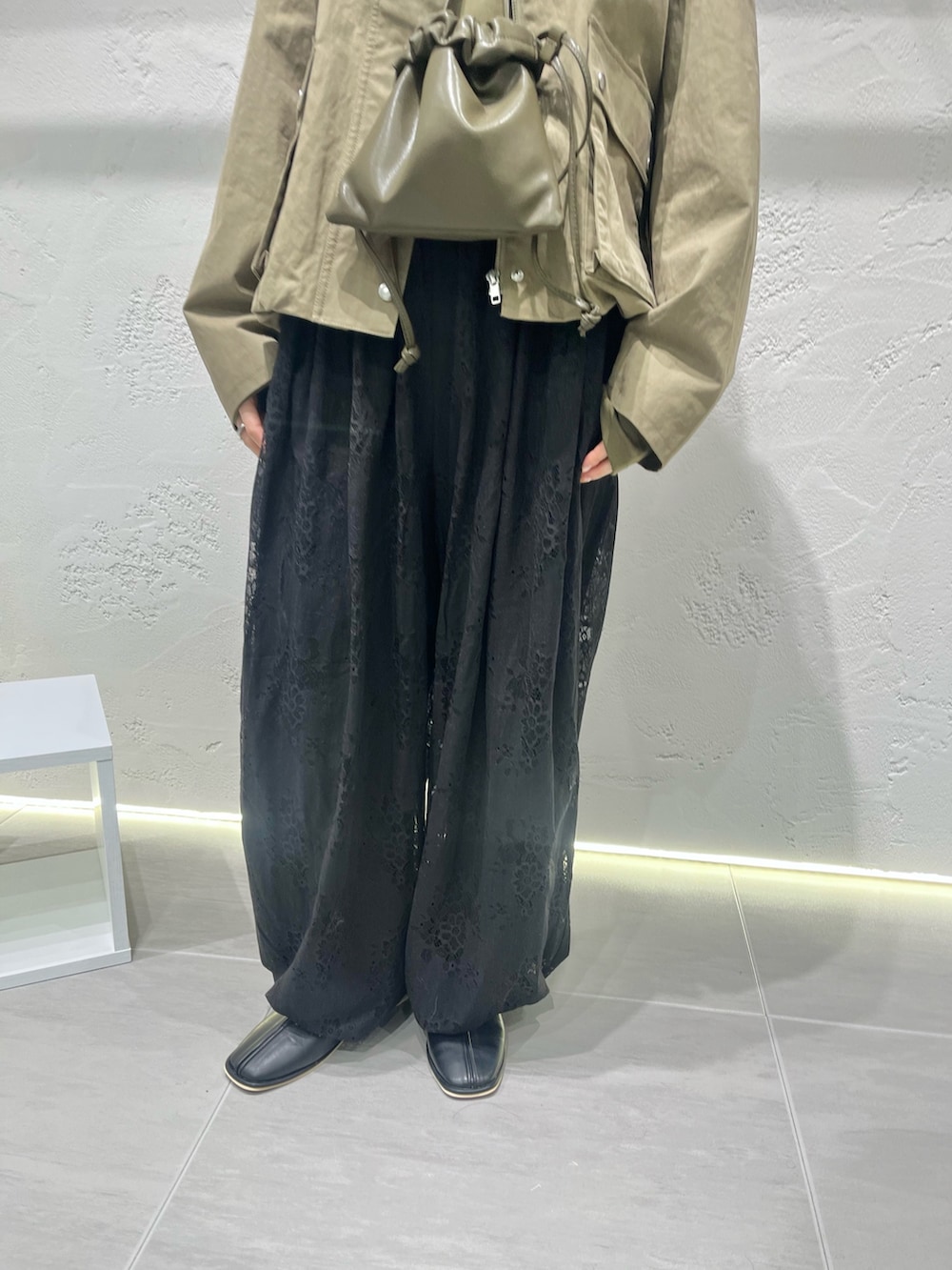 ブラック系のその他パンツ、ブラック系のパンプス、グリーン系のショルダーバッグを着用したレディースの冬コーディネートの2枚目の写真