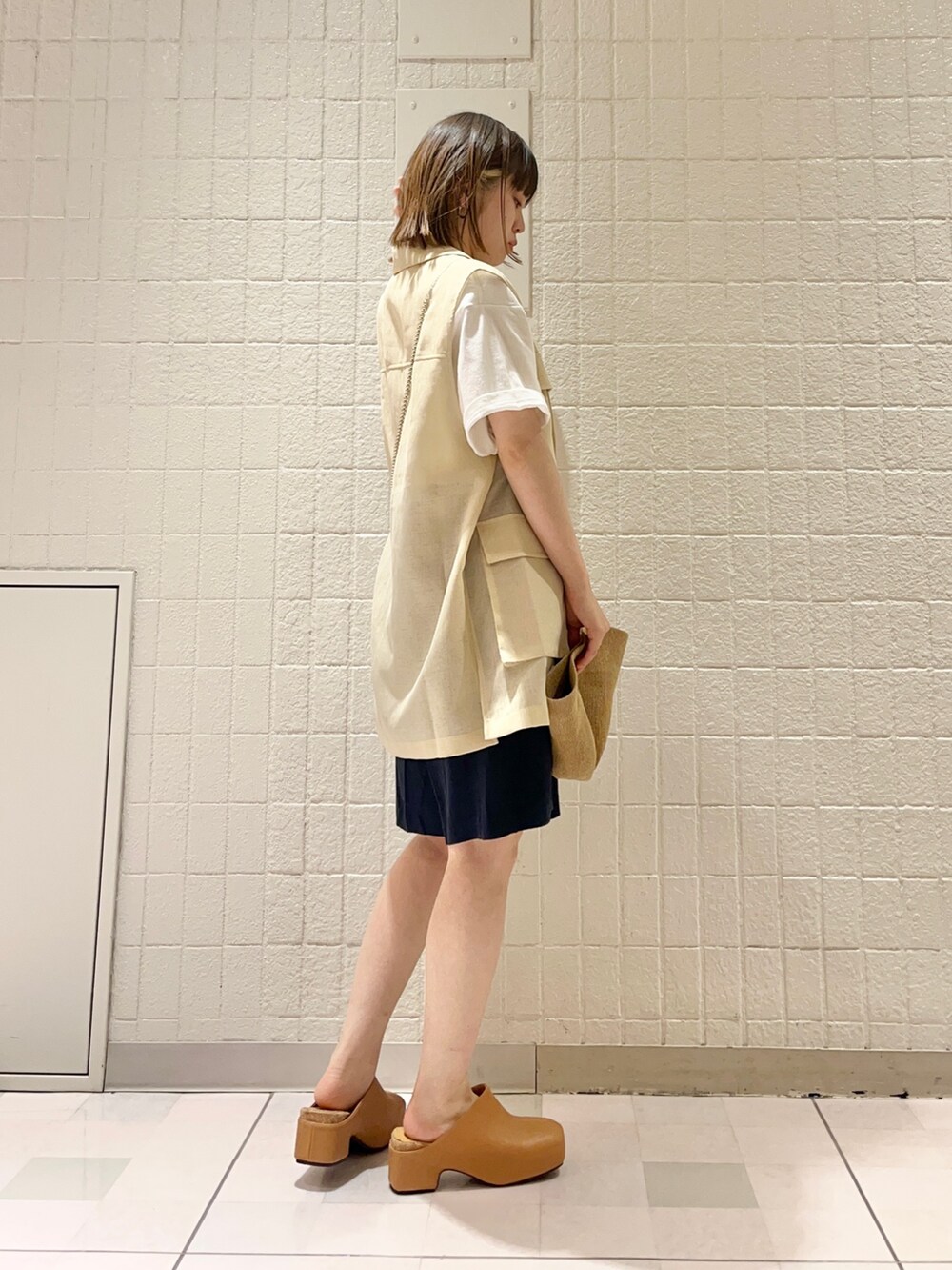 ベージュ系のベスト、ホワイト系のTシャツ/カットソー、ブルー系のその他パンツを着用したレディースの春コーディネートの2枚目の写真