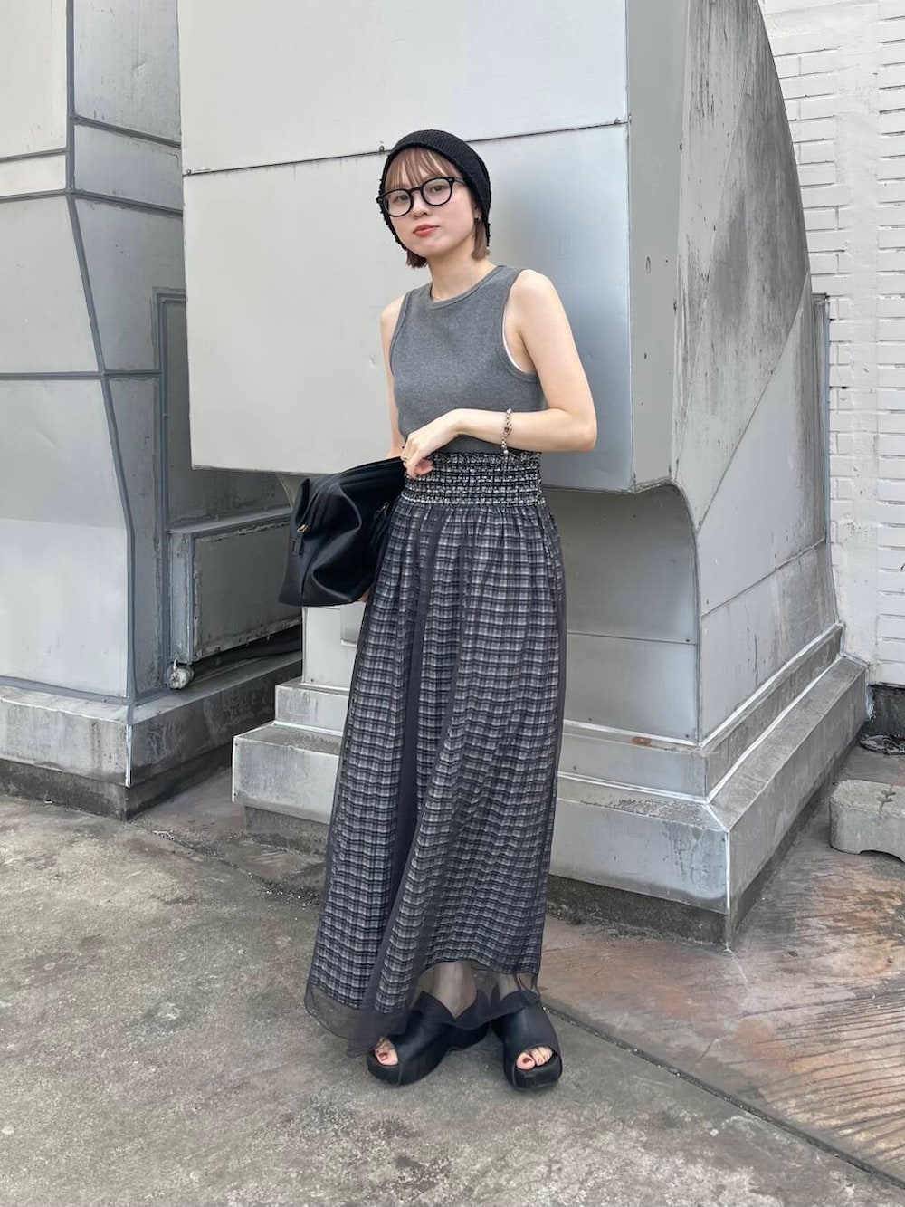 グレー系のタンクトップ、ブラック系のスカート、ブラック系のボストンバッグを着用したレディースの夏コーディネートの5枚目の写真