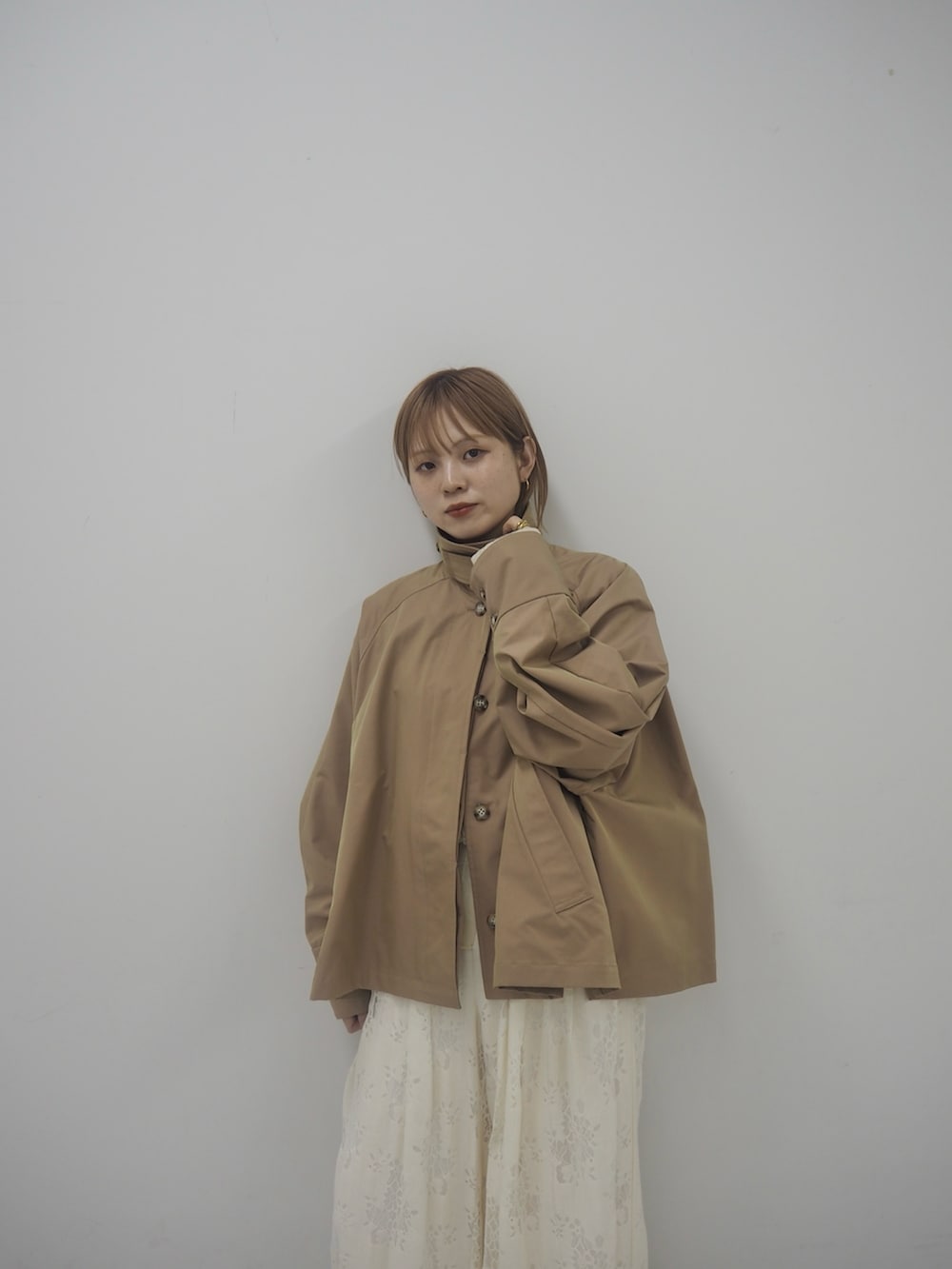 ベージュ系のステンカラーコート、ホワイト系のその他パンツ、ブラウン系のその他シューズを着用したレディースの冬コーディネートの3枚目の写真