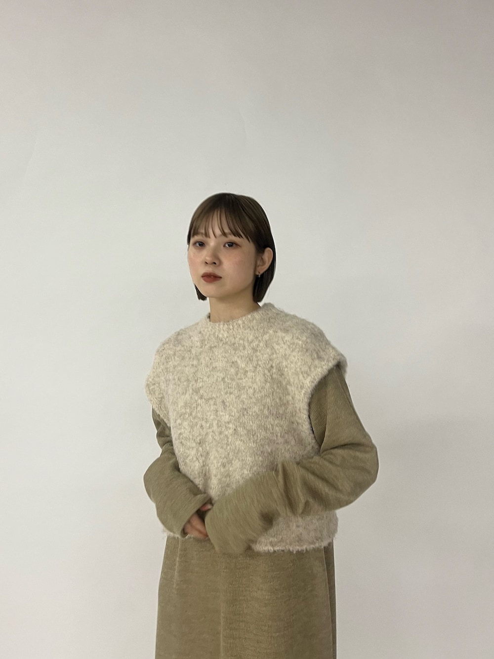 ベージュ系のワンピース、ブラック系のブーツを着用したレディースの秋コーディネートの3枚目の写真