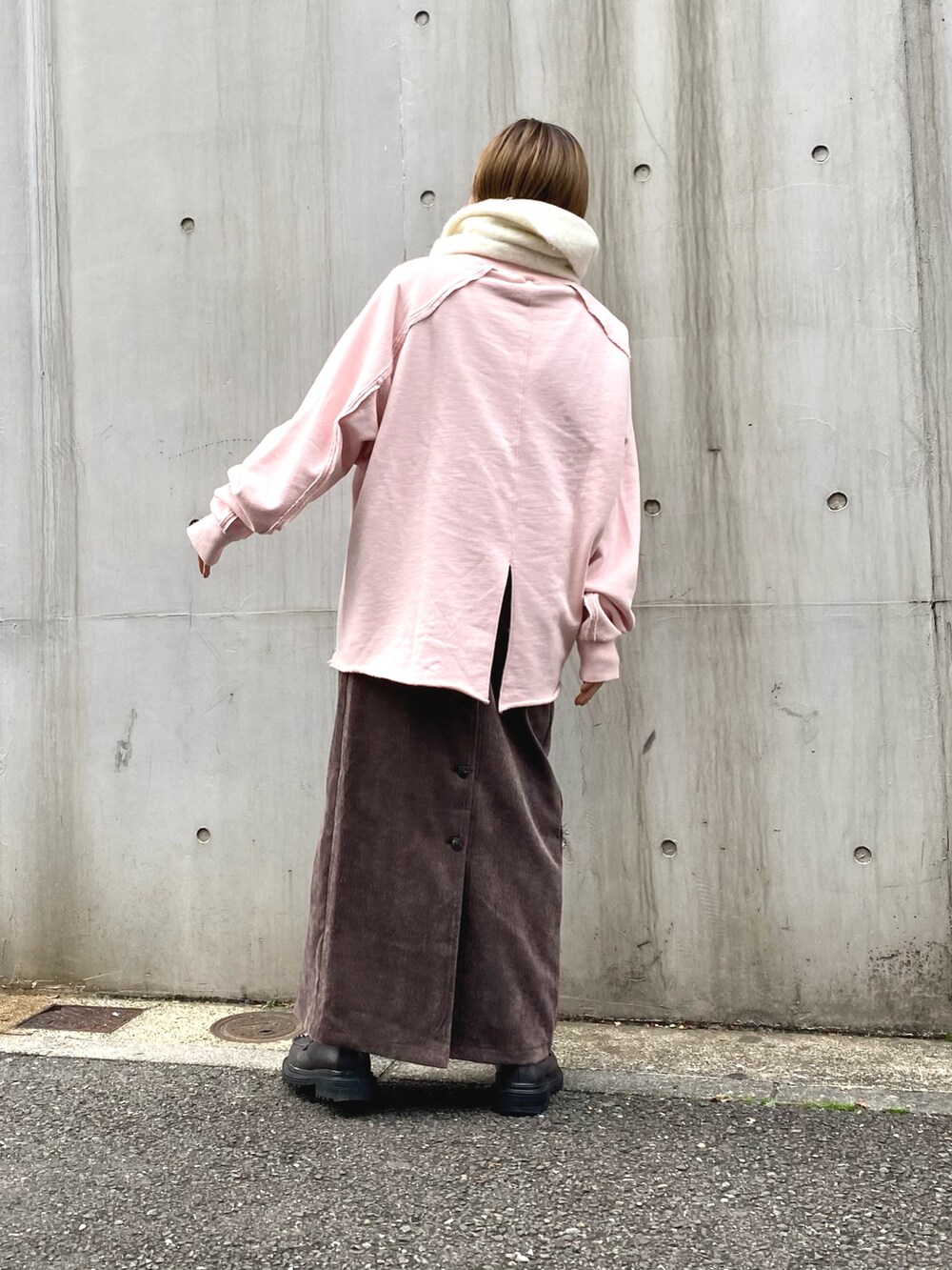 グレー系のブーツ、ブラウン系のワンピース、ベージュ系のスウェットを着用したレディースの冬コーディネートの2枚目の写真