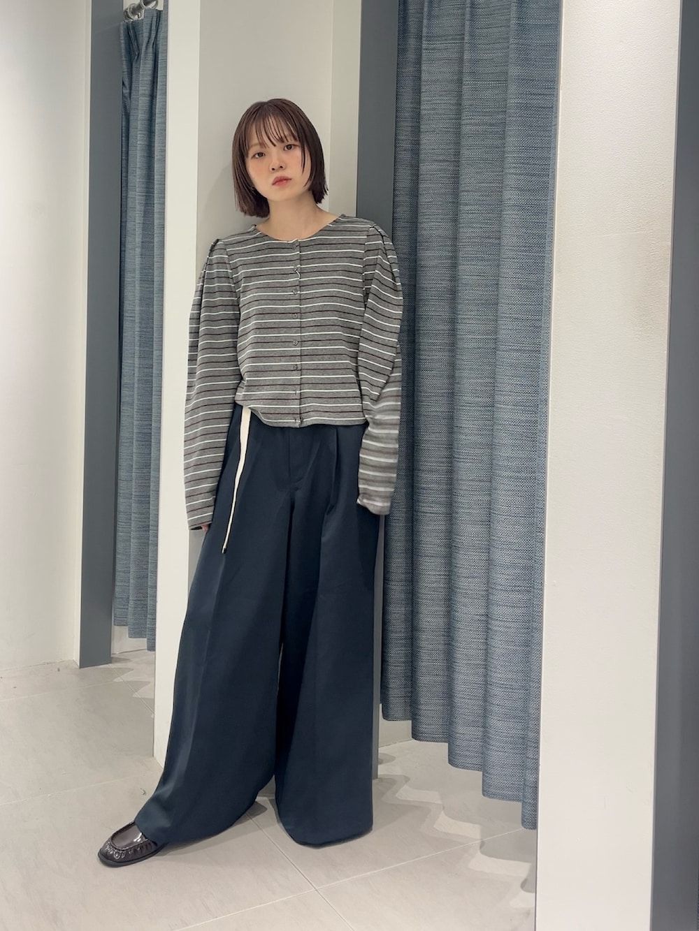 ブルー系のその他パンツ、ブラック系のローファー、グレー系のカーディガン/ボレロを着用したレディースの秋コーディネートの2枚目の写真