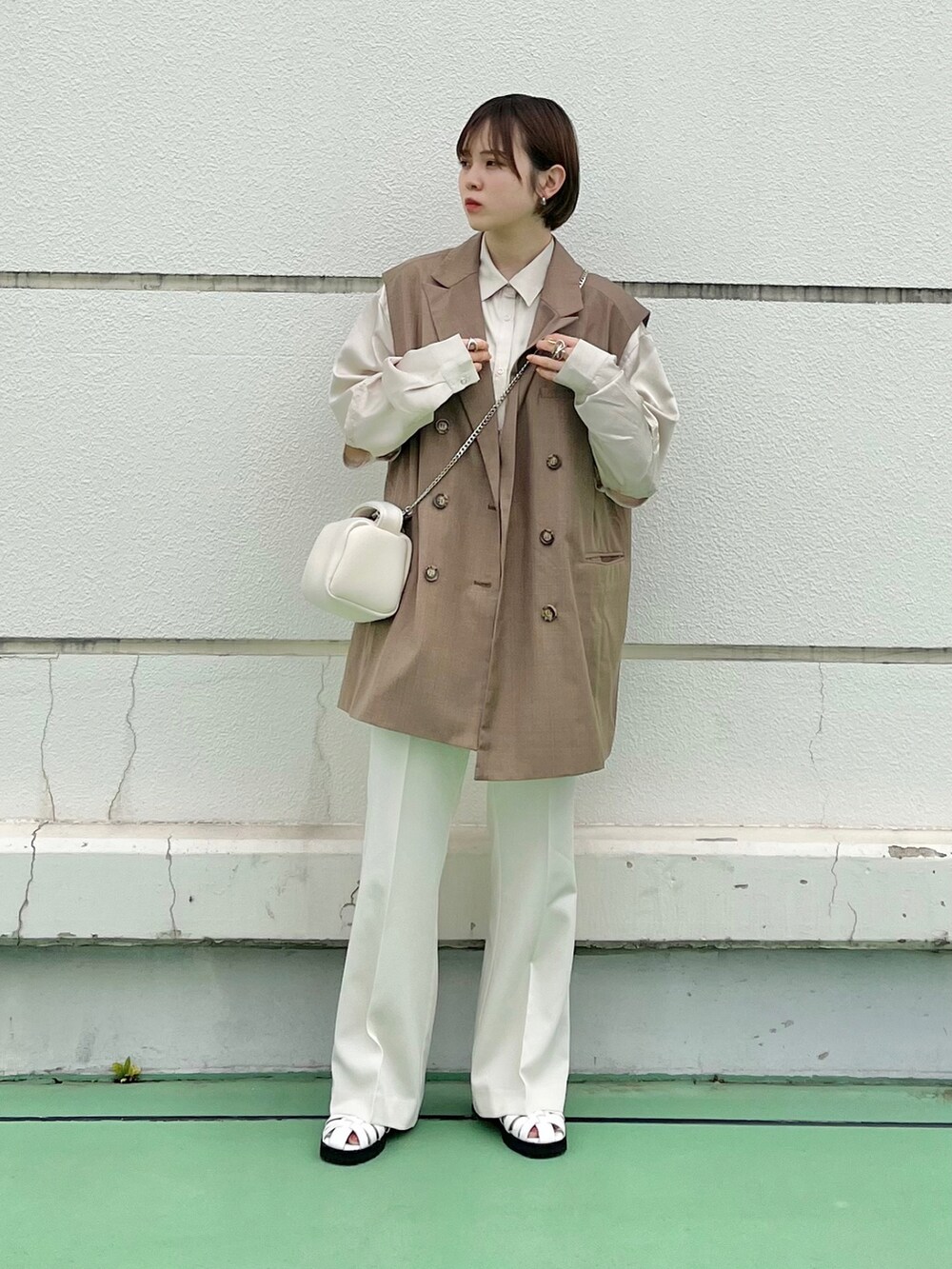 ブルー系のベスト、ホワイト系のハンドバッグ、ブラウン系のシャツ/ブラウスを着用したレディースの春コーディネートの4枚目の写真