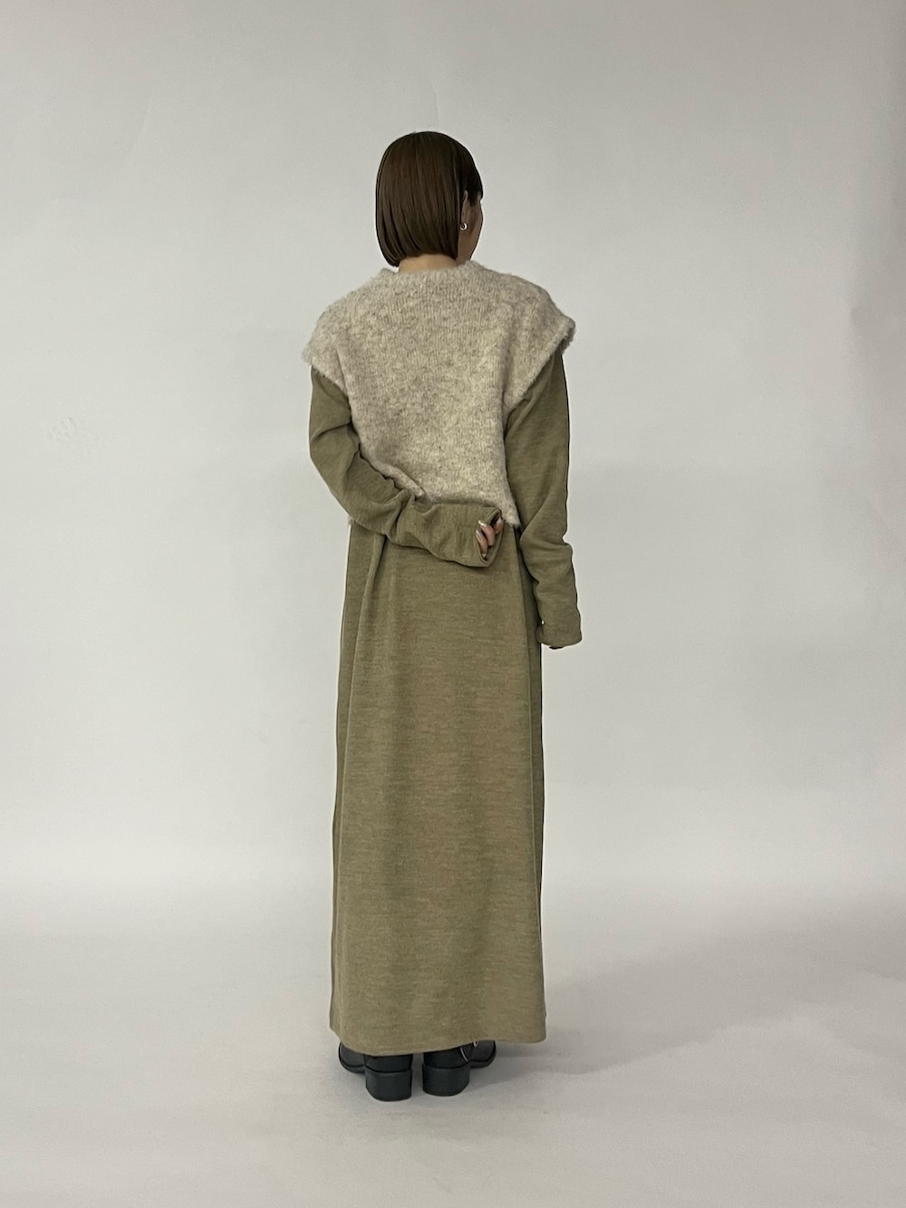 ベージュ系のワンピース、ブラック系のブーツを着用したレディースの秋コーディネートの2枚目の写真