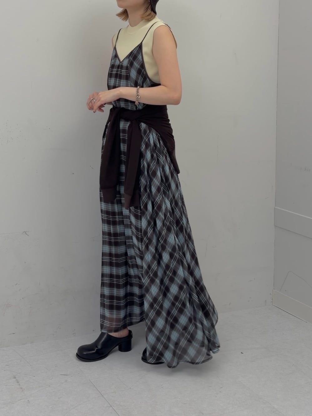 ブラウン系のワンピース、ブラウン系のシャツ/ブラウス、ブラック系のサンダルを着用したレディースの春コーディネートの2枚目の写真