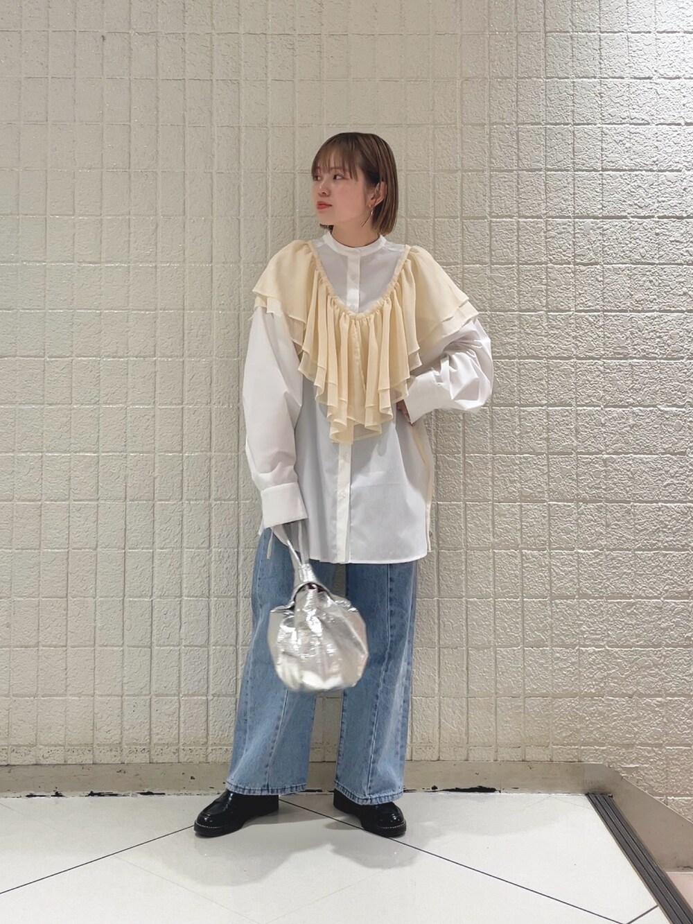 ホワイト系のシャツ/ブラウス、ブルー系のデニムパンツ、シルバー系のハンドバッグを着用したレディースの春コーディネートの3枚目の写真