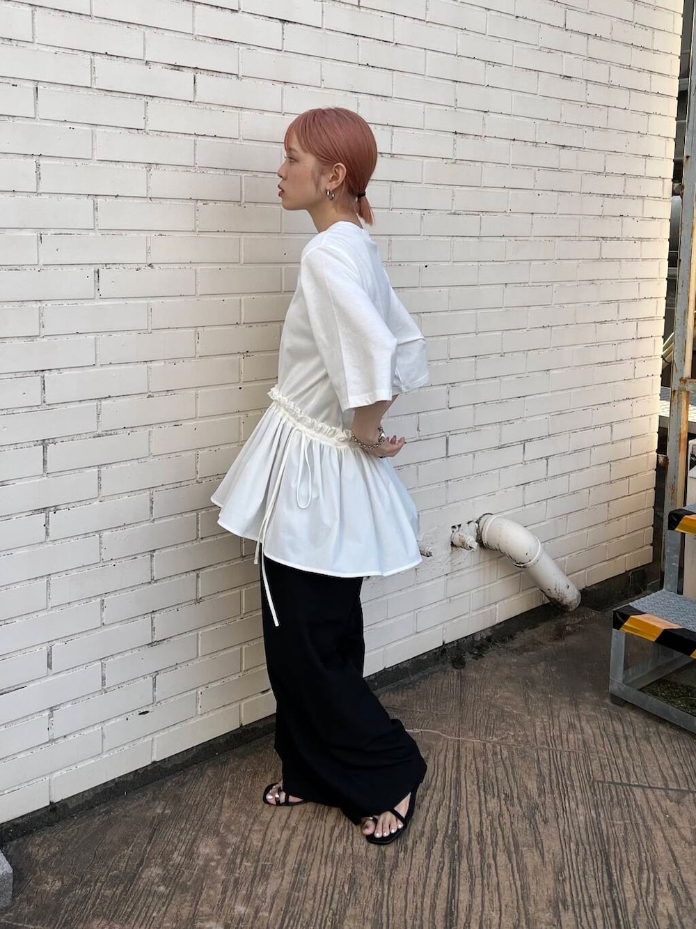 ブラック系のセットアップ、ブラック系のサンダル、ホワイト系のTシャツ/カットソーを着用したレディースの夏コーディネートの2枚目の写真