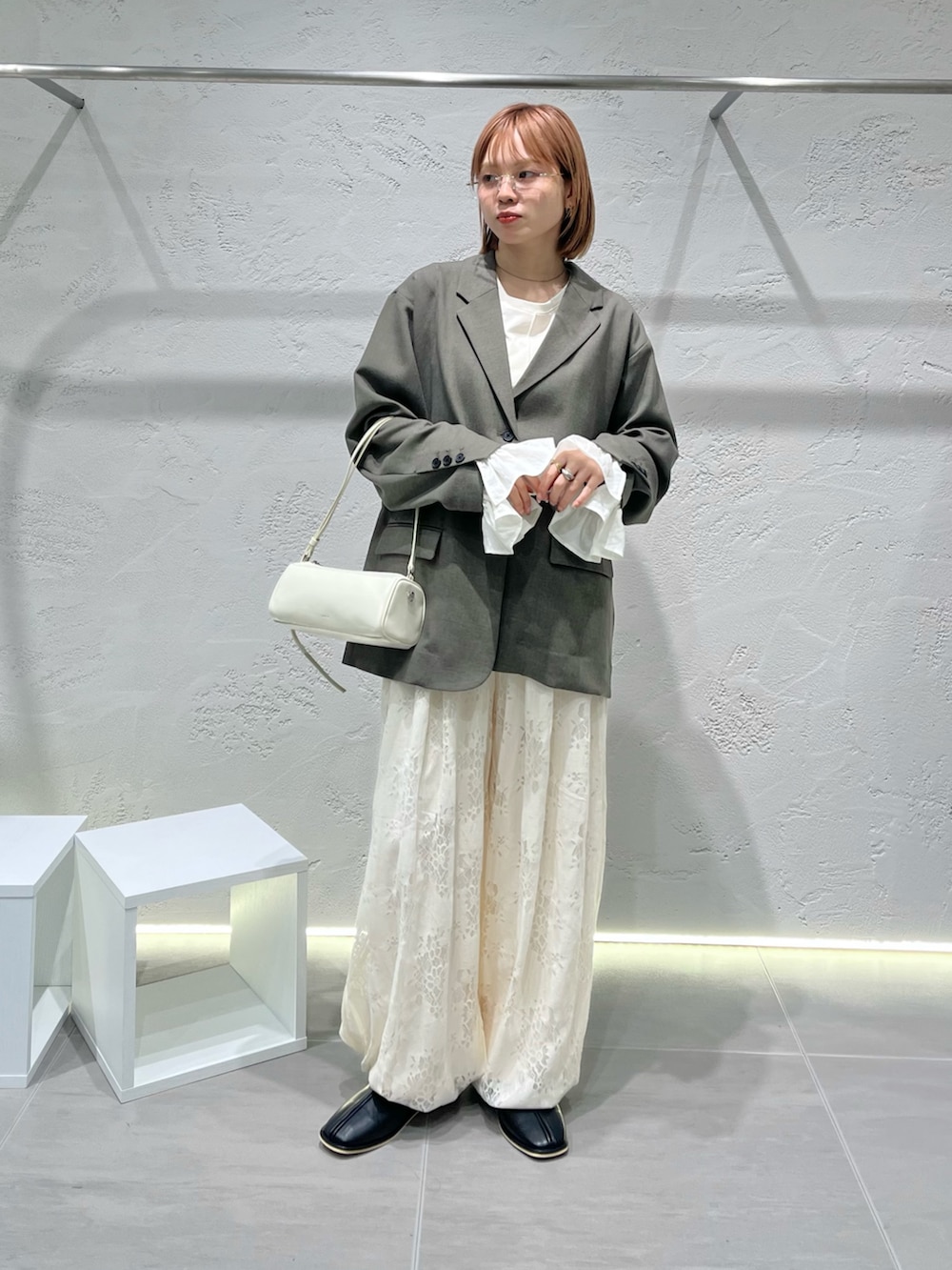 グレー系のその他アウター、ホワイト系のその他パンツ、ブラック系のパンプスを着用したレディースの冬コーディネートの3枚目の写真