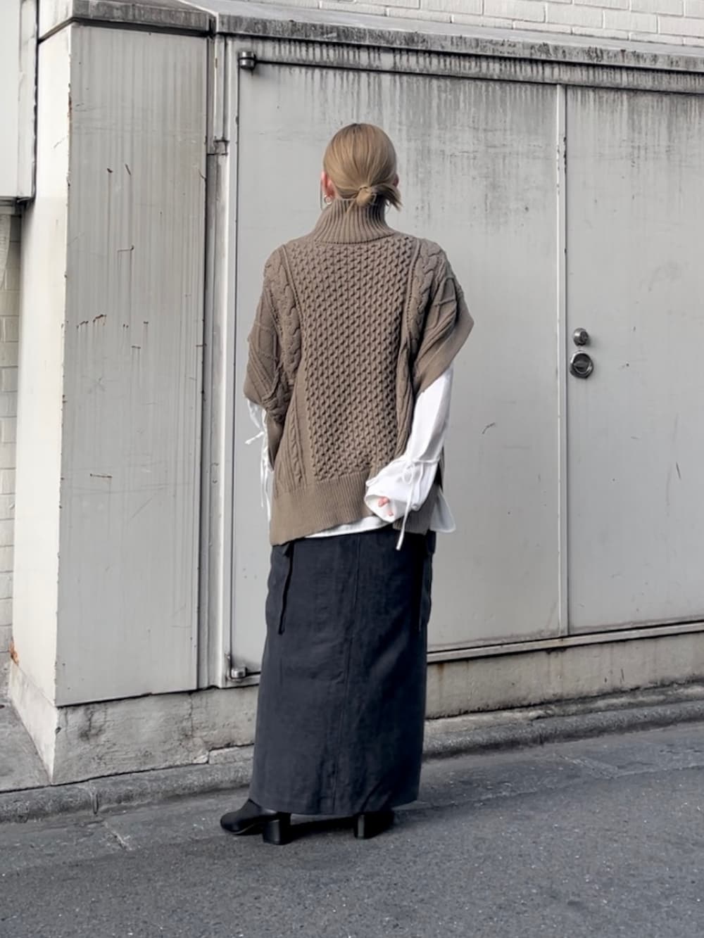 ブラウン系のトップス、ホワイト系のトップス、ブラック系のスカートを着用したレディースの秋コーディネートの2枚目の写真