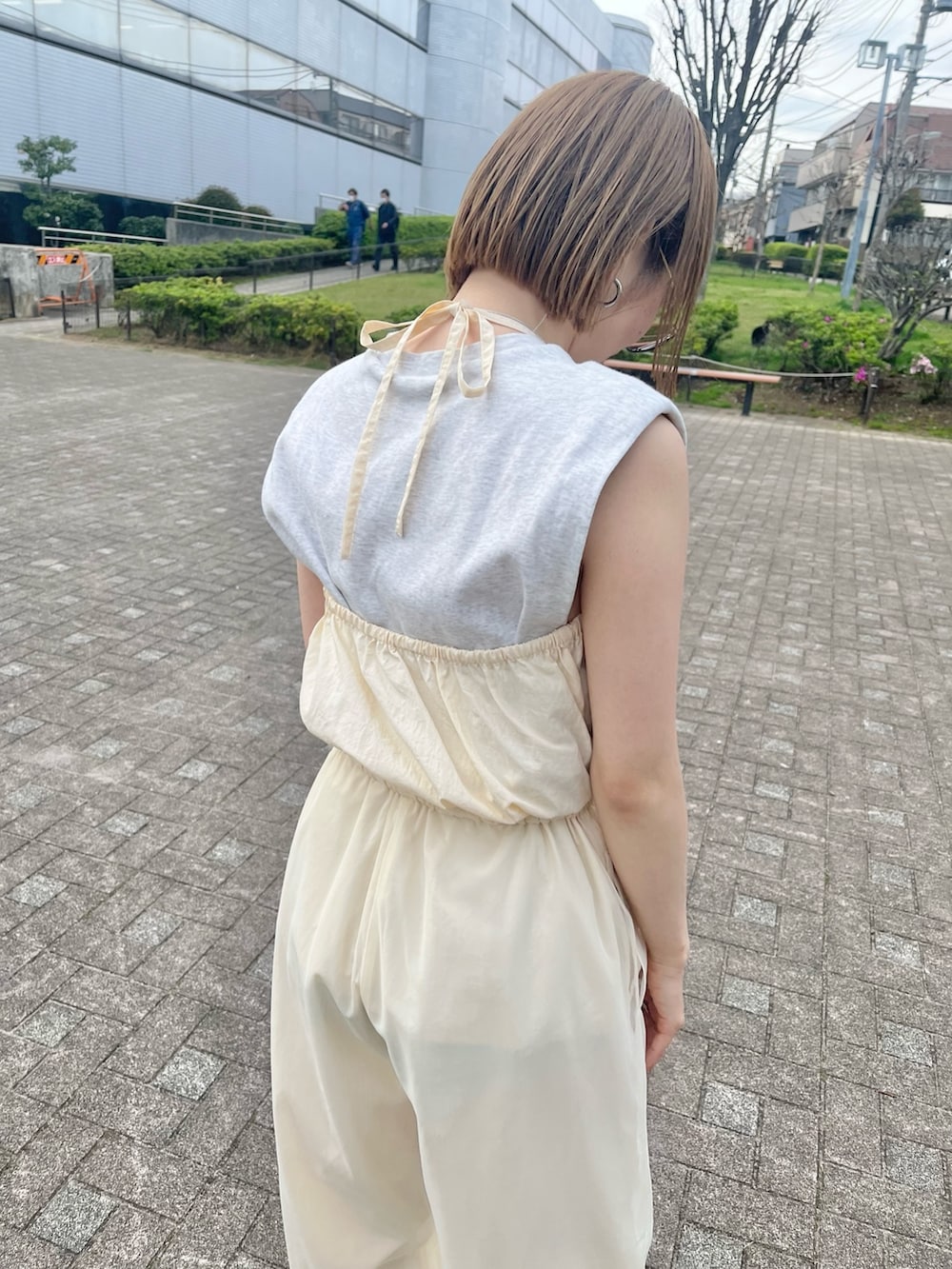 イエロー系のサンダル、ホワイト系のサロペット/オーバーオールを着用したレディースの春コーディネートの4枚目の写真