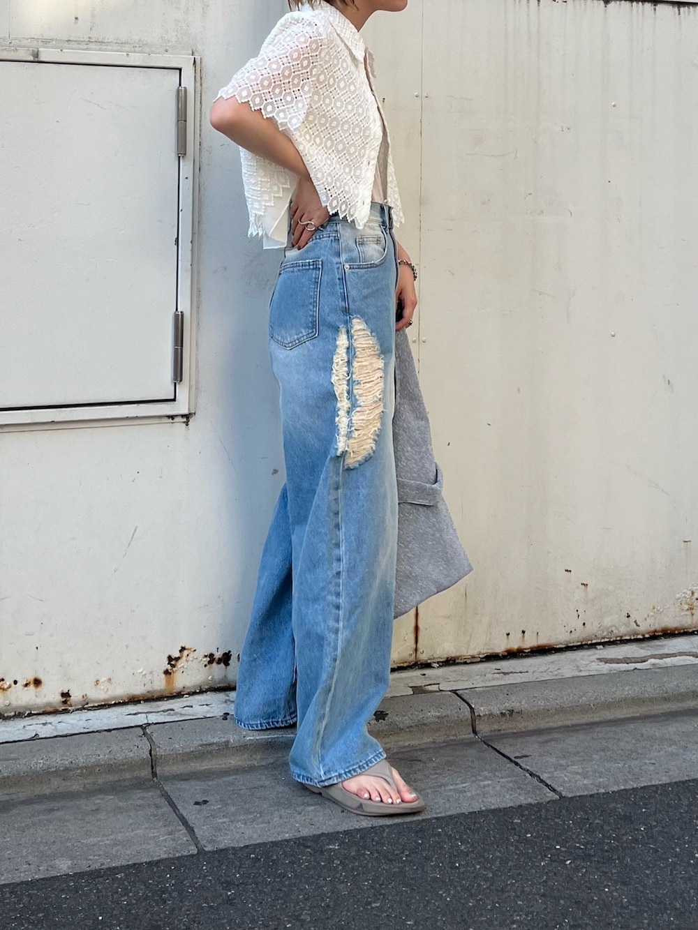 ブルー系のデニムパンツ、シルバー系のトートバッグ、ホワイト系のシャツ/ブラウスを着用したレディースの夏コーディネートの2枚目の写真