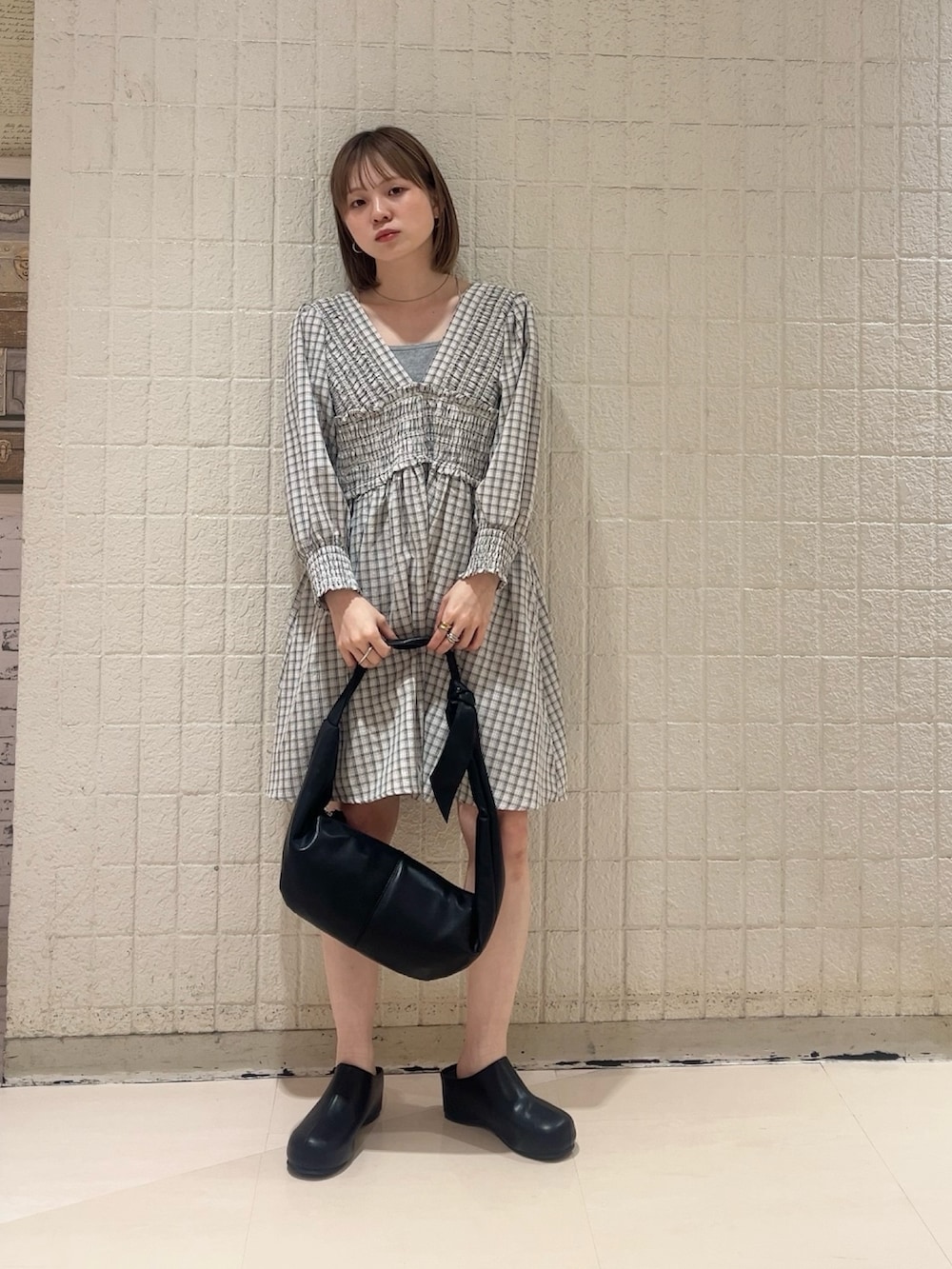 ベージュ系のワンピース、ブラック系のその他パンツ、ブラック系のショルダーバッグを着用したレディースの春コーディネートの4枚目の写真