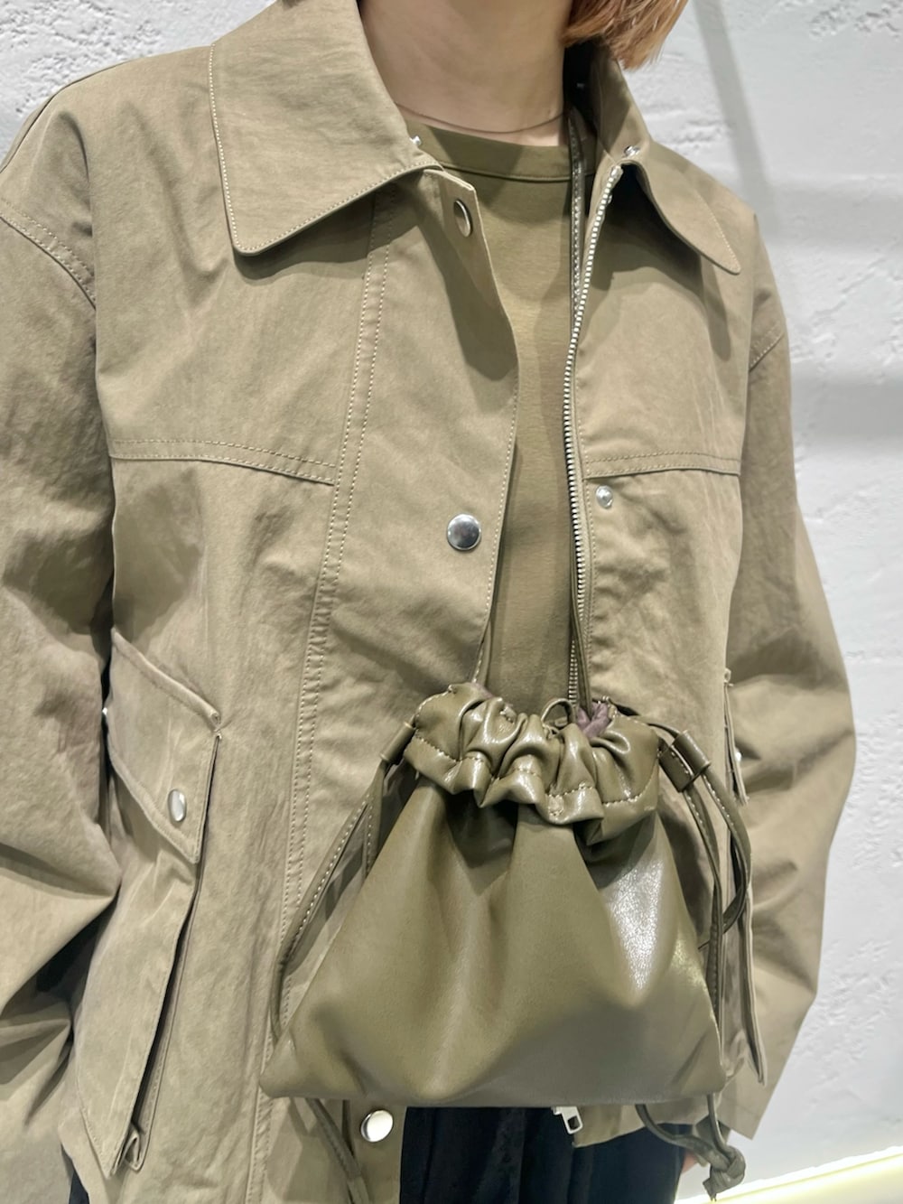 ブラック系のその他パンツ、ブラック系のパンプス、グリーン系のショルダーバッグを着用したレディースの冬コーディネートの3枚目の写真