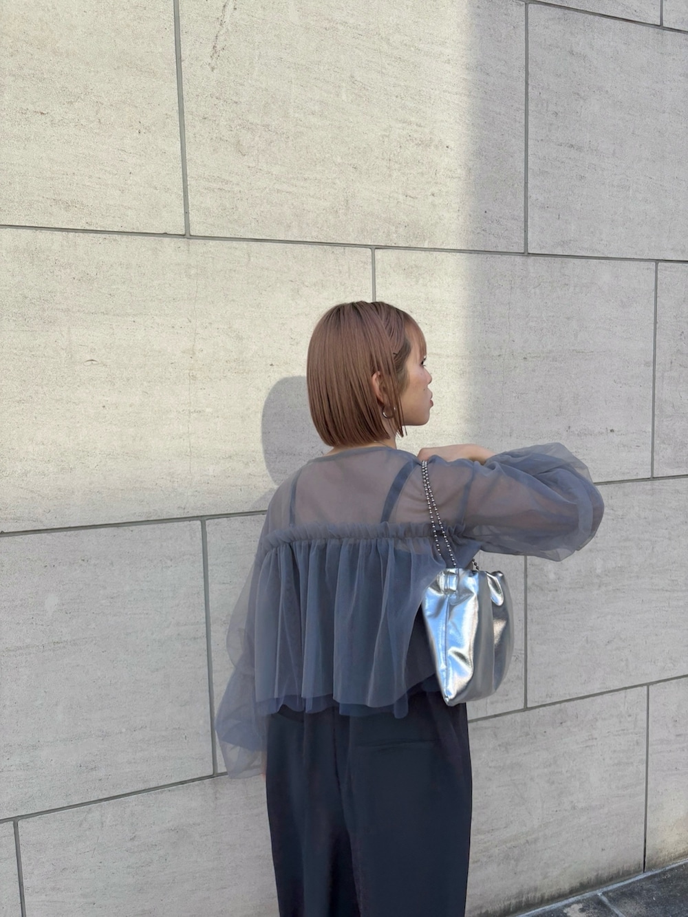 シルバー系のハンドバッグ、シルバー系のパンプス、グレー系のサロペット/オーバーオールを着用したレディースの冬コーディネートの2枚目の写真