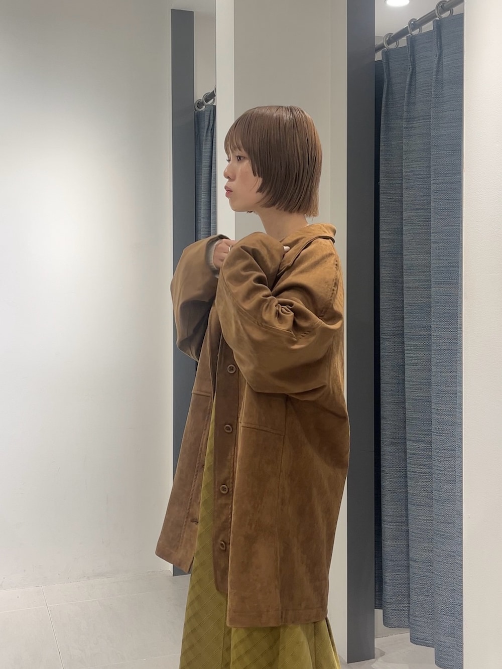 ホワイト系のニット/セーター、ブラウン系のカバーオール、イエロー系のワンピースを着用したレディースの秋コーディネートの2枚目の写真