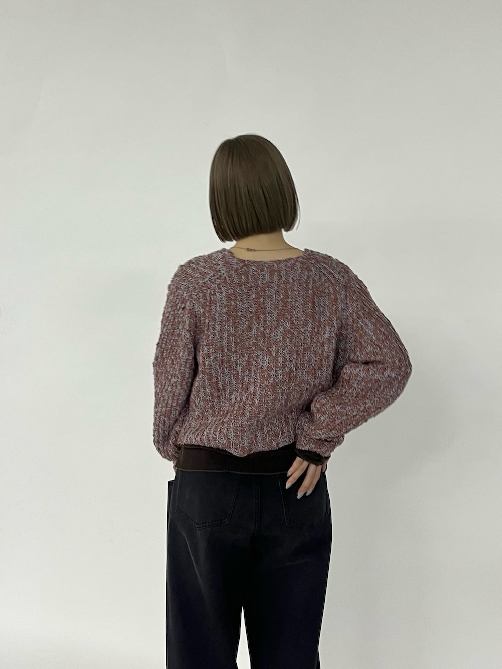 ブラック系のデニムパンツ、ブラウン系のスニーカー、ブラウン系のニット/セーターを着用したレディースの秋コーディネートの3枚目の写真