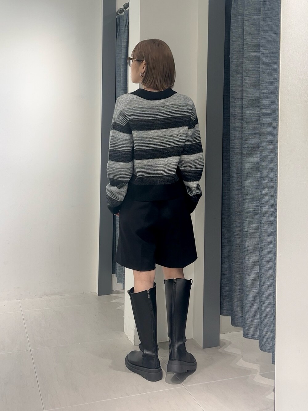 ブラック系のその他パンツ、ブラック系のカーディガン/ボレロ、ブラック系のブーツを着用したレディースの秋コーディネートの3枚目の写真