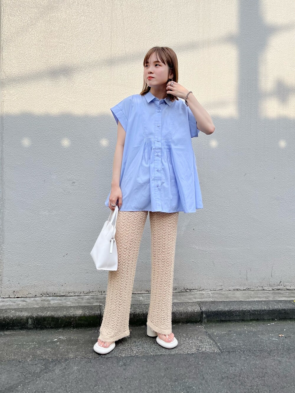 ホワイト系のサンダル、ホワイト系のハンドバッグ、ベージュ系のその他パンツを着用したレディースの夏コーディネートの5枚目の写真