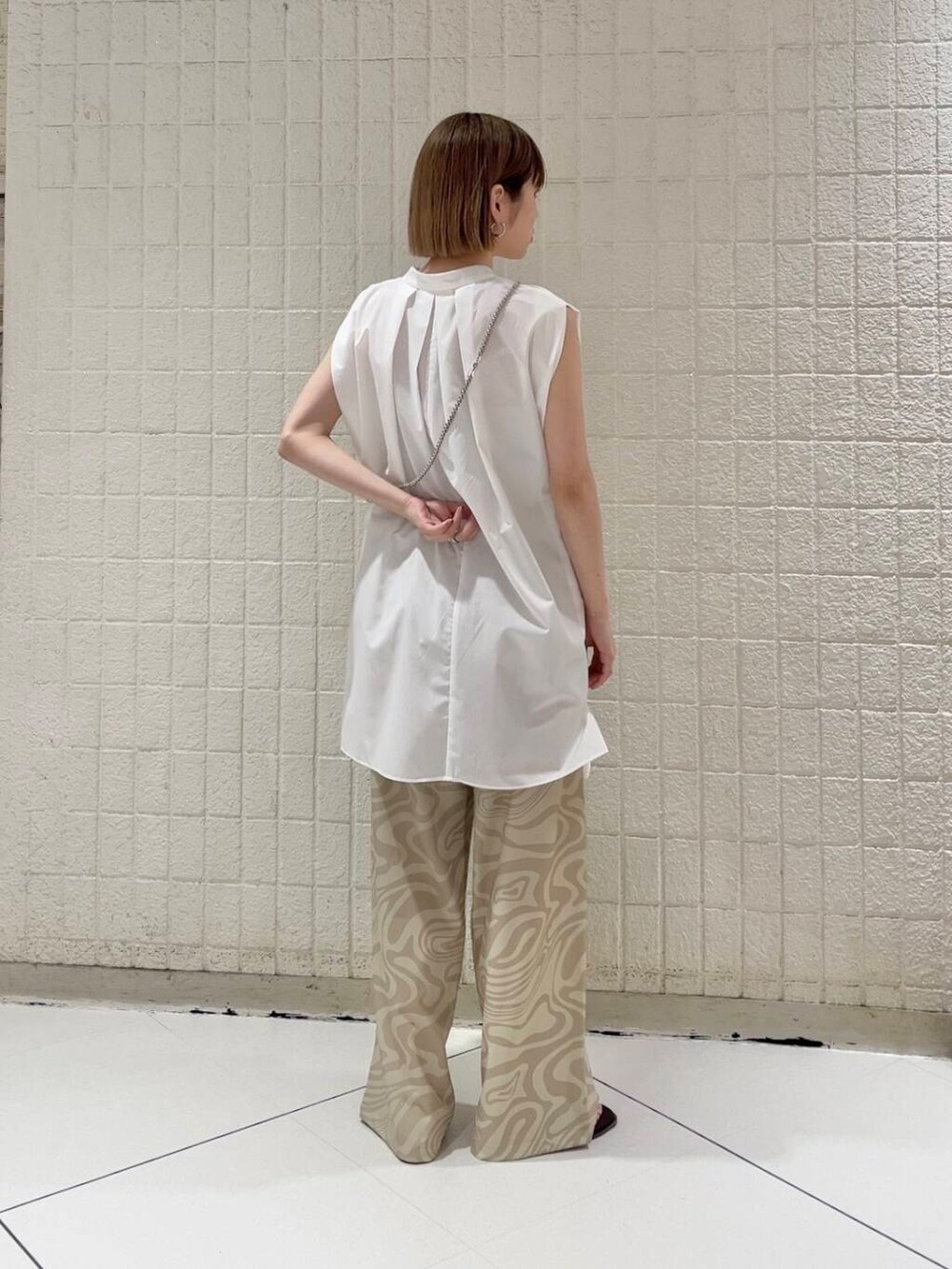 ベージュ系のその他パンツ、レッド系のサンダル、ホワイト系のシャツ/ブラウスを着用したレディースの春コーディネートの2枚目の写真