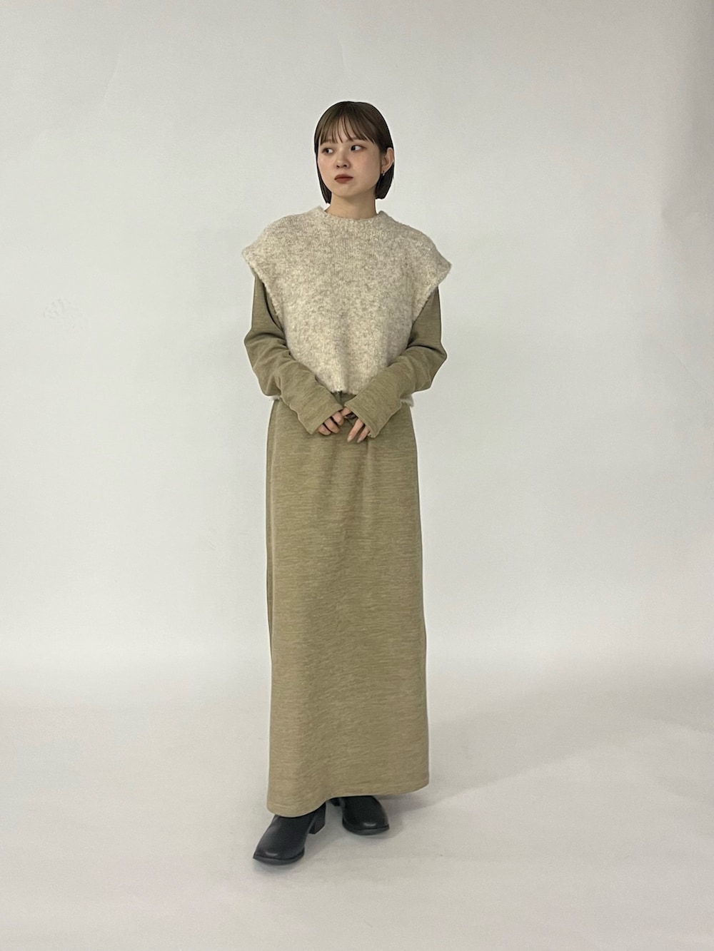 ベージュ系のワンピース、ブラック系のブーツを着用したレディースの秋コーディネートの5枚目の写真