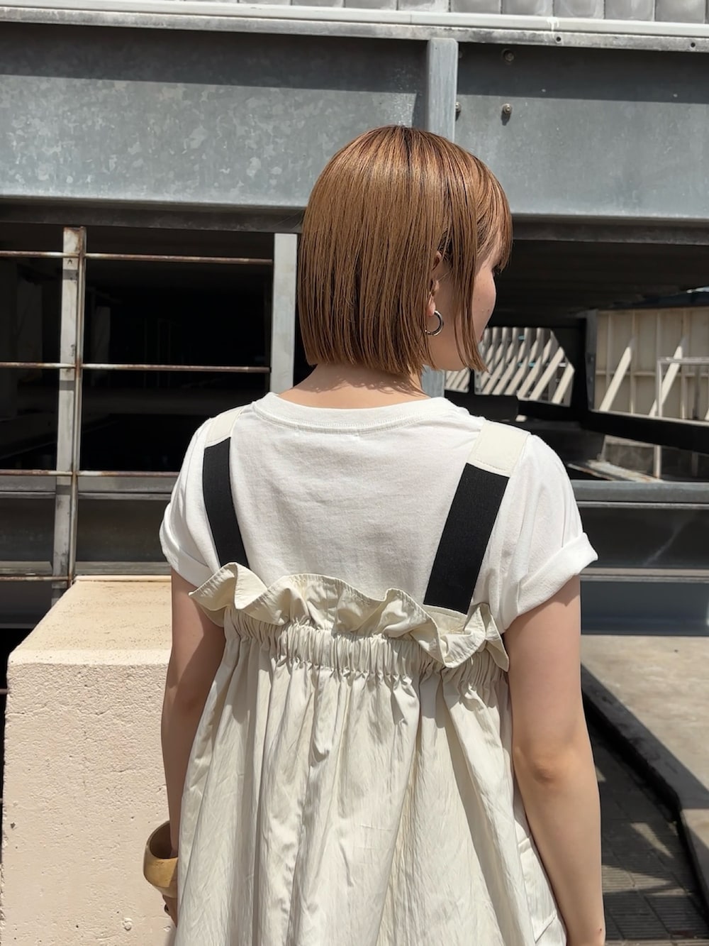 ホワイト系のワンピース、ホワイト系のTシャツ/カットソー、イエロー系のサンダルを着用したレディースの春コーディネートの2枚目の写真