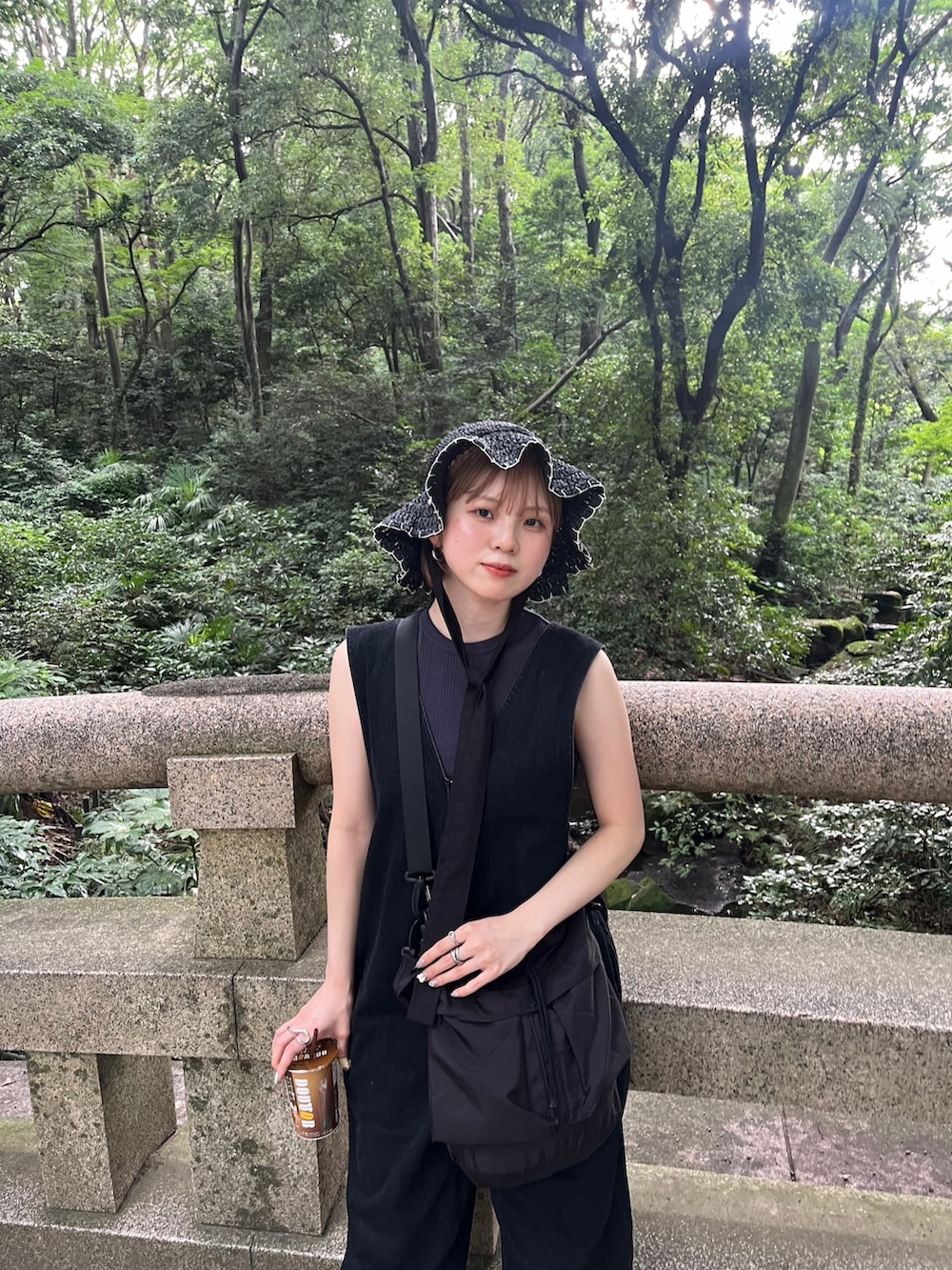 ブルー系のタンクトップ、ブラック系のサンダル、ブラック系のショルダーバッグを着用したレディースの夏コーディネートの2枚目の写真