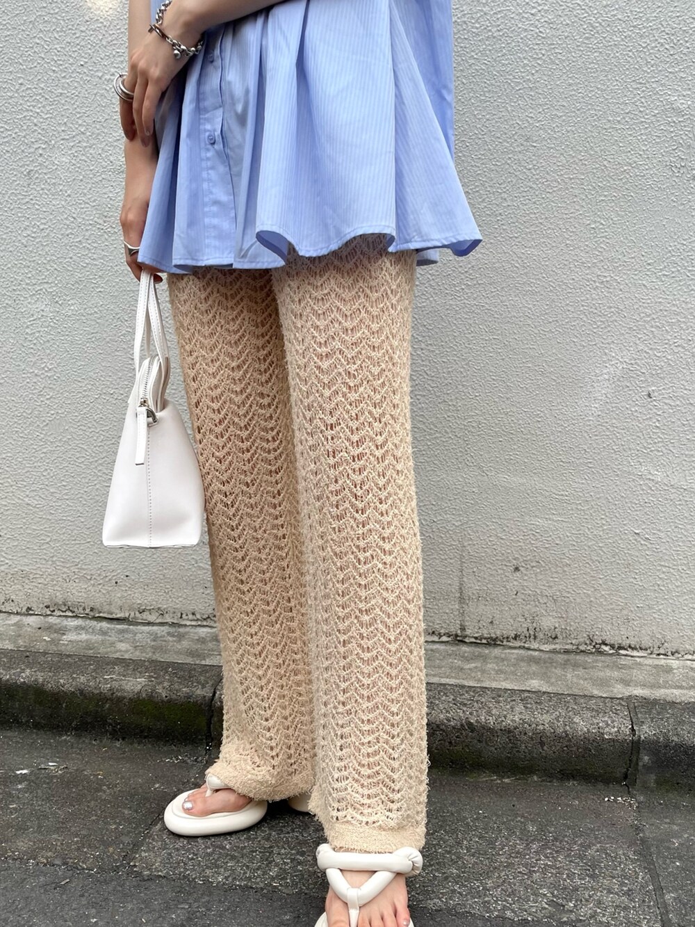 ホワイト系のサンダル、ホワイト系のハンドバッグ、ベージュ系のその他パンツを着用したレディースの夏コーディネートの4枚目の写真