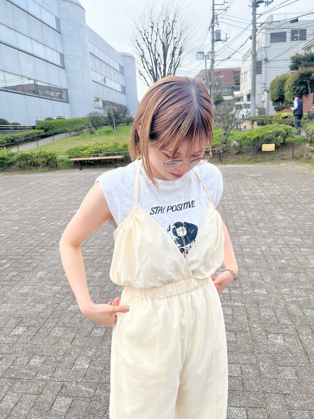 イエロー系のサンダル、ホワイト系のサロペット/オーバーオールを着用したレディースの春コーディネートの3枚目の写真